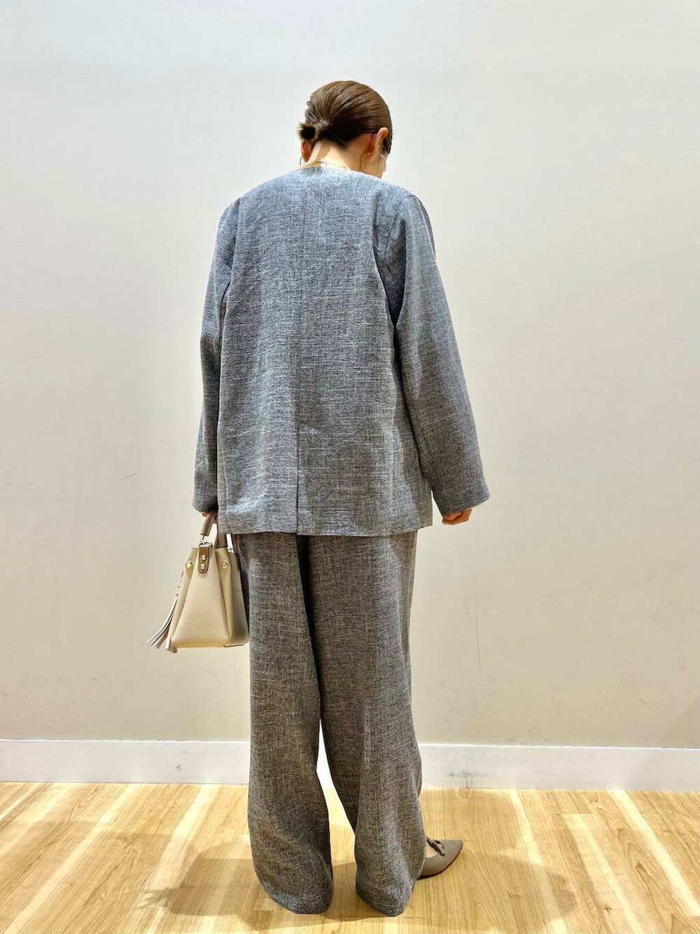 ホワイト系のトートバッグ、グレー系のパンプス、ブラック系のノーカラージャケットを着用したレディースの冬コーディネートの4枚目の写真