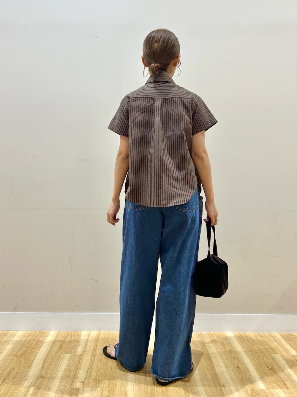 ブラウン系のシャツ/ブラウス、ブルー系のデニムパンツ、ブラック系のトートバッグを着用したレディースの夏コーディネートの3枚目の写真