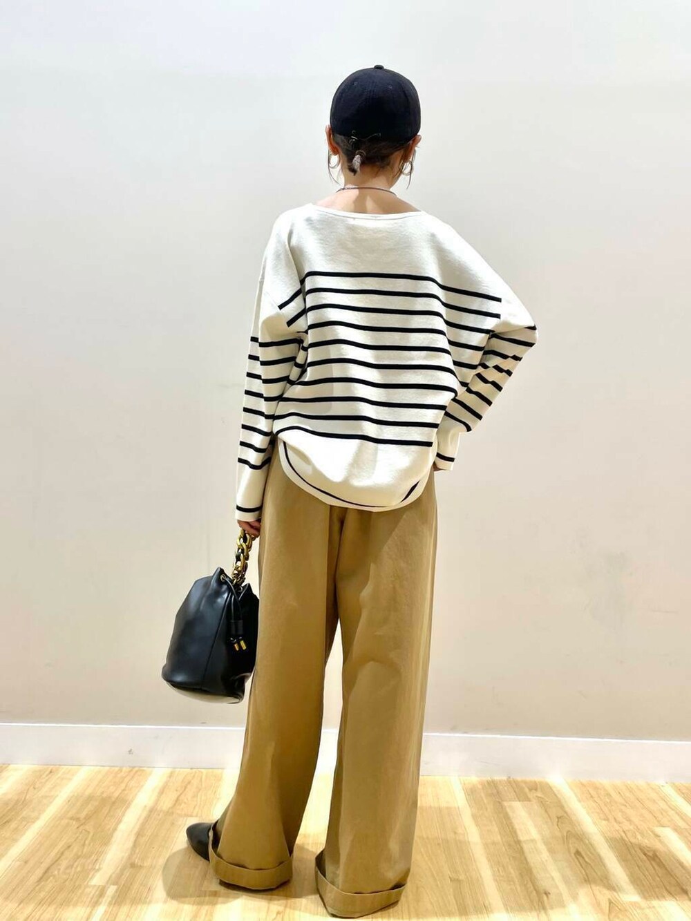 ブラック系のパンプス、ブラック系のショルダーバッグ、ブラック系のニット/セーターを着用したレディースの秋コーディネートの4枚目の写真