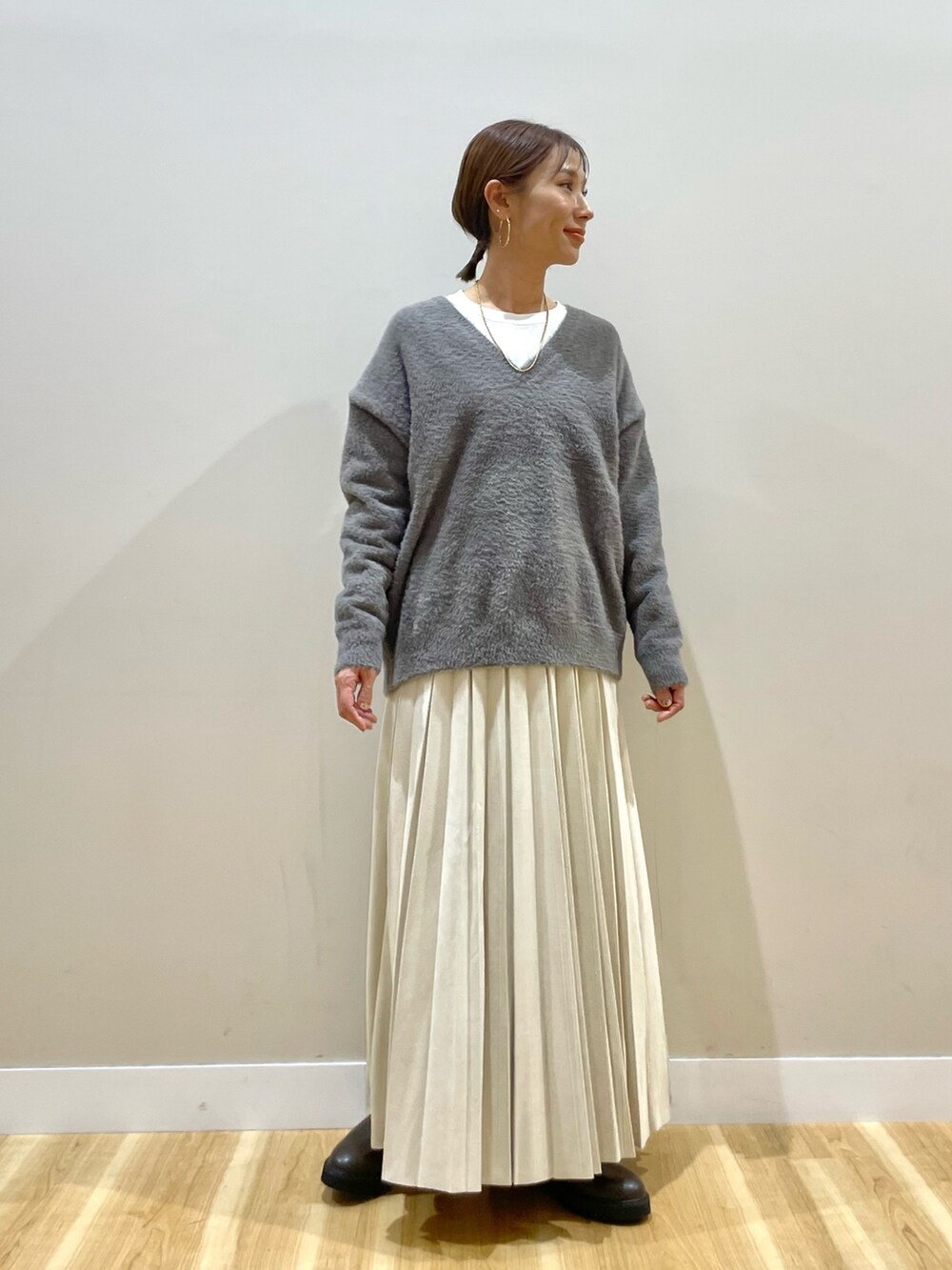 グレー系のニット/セーター、グレー系のダウンジャケット/コート、ホワイト系のTシャツ/カットソーを着用したレディースの冬コーディネートの5枚目の写真