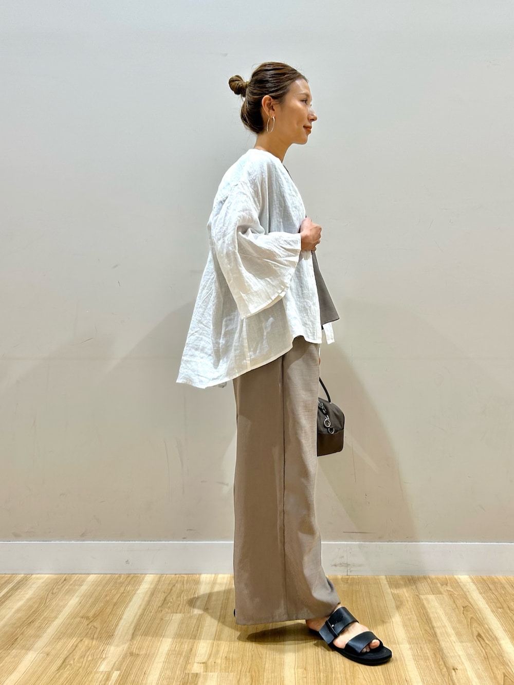 ホワイト系のシャツ/ブラウス、ベージュ系のサロペット/オーバーオール、ブラウン系のボストンバッグを着用したレディースの春コーディネートの2枚目の写真