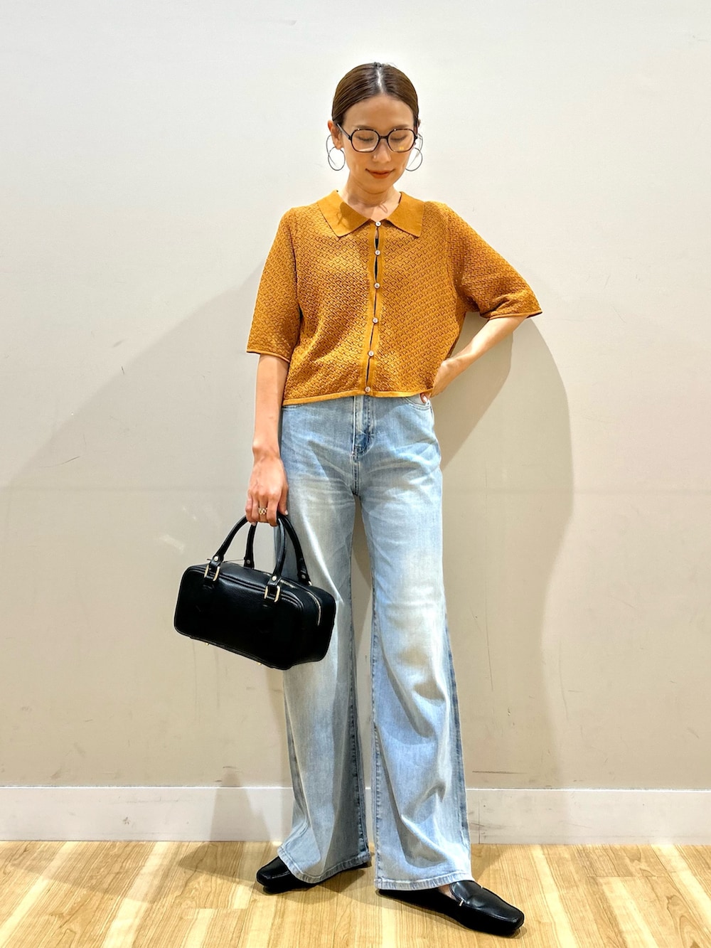 ブラウン系のニット/セーター、ブルー系のデニムパンツ、ブラック系のハンドバッグを着用したレディースの夏コーディネートの5枚目の写真