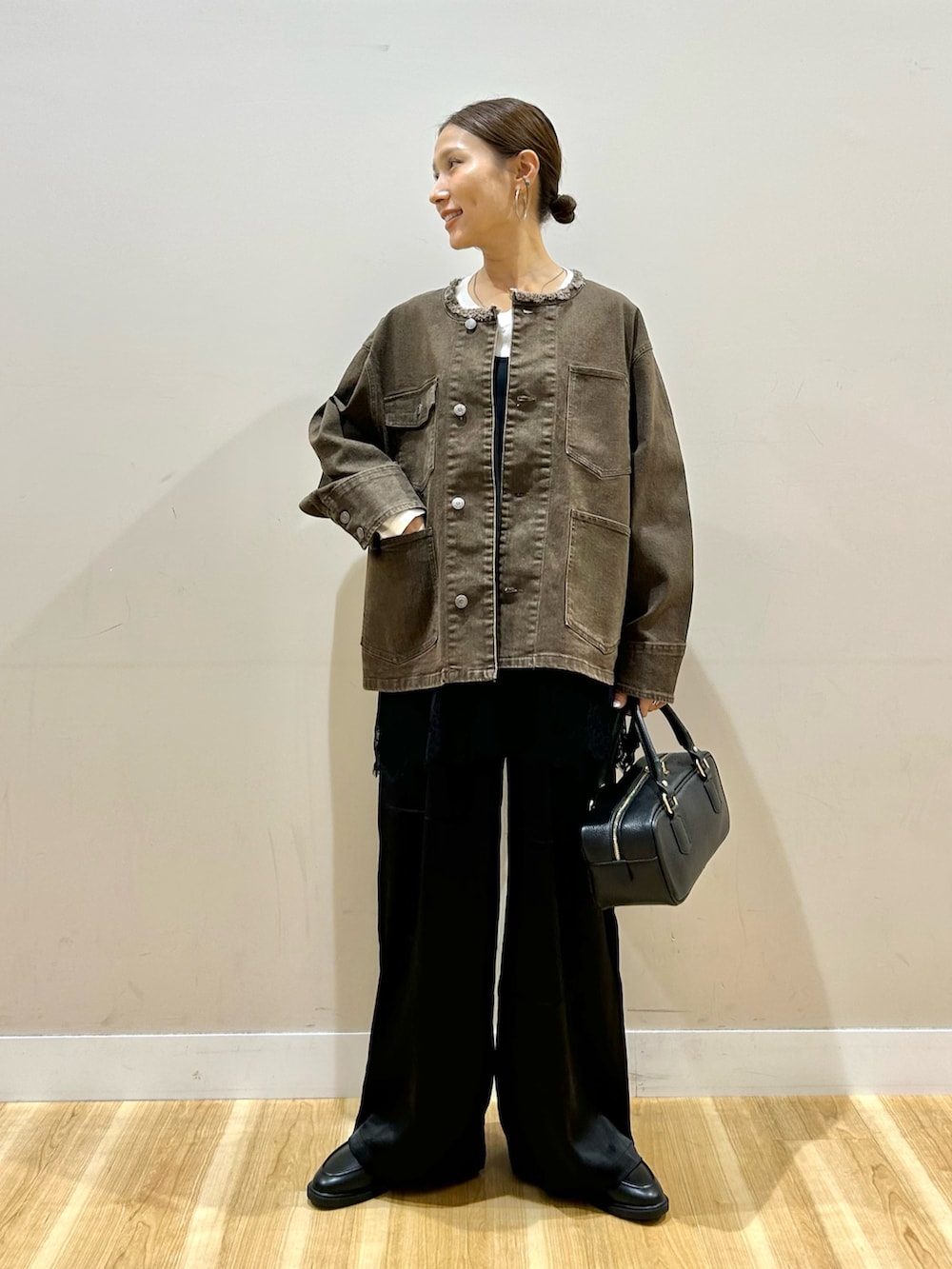ブラウン系のデニムジャケット、ホワイト系のTシャツ/カットソー、ブラック系のその他パンツを着用したレディースの秋コーディネートの5枚目の写真