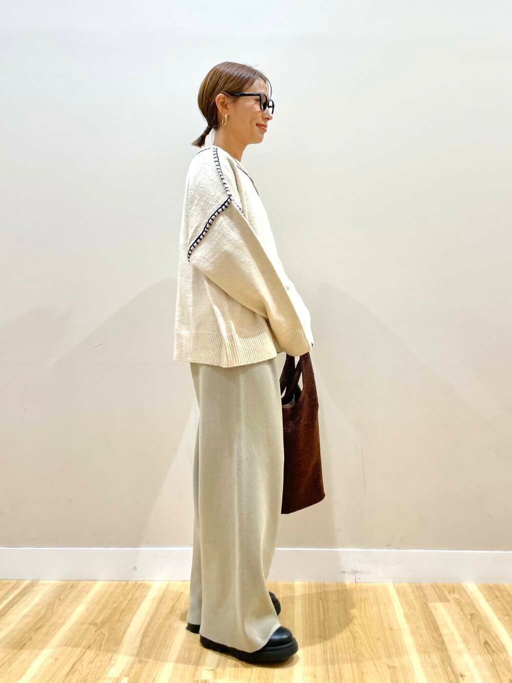 ホワイト系のニット/セーター、ブラック系のダウンジャケット/コート、ベージュ系のその他パンツを着用したレディースの冬コーディネートの6枚目の写真