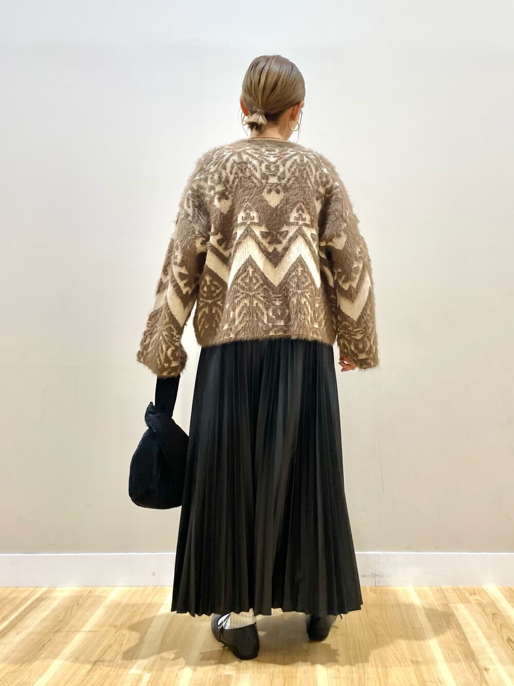 ベージュ系のカーディガン/ボレロ、ブラウン系のニット/セーター、ブラック系のスカートを着用したレディースの冬コーディネートの7枚目の写真