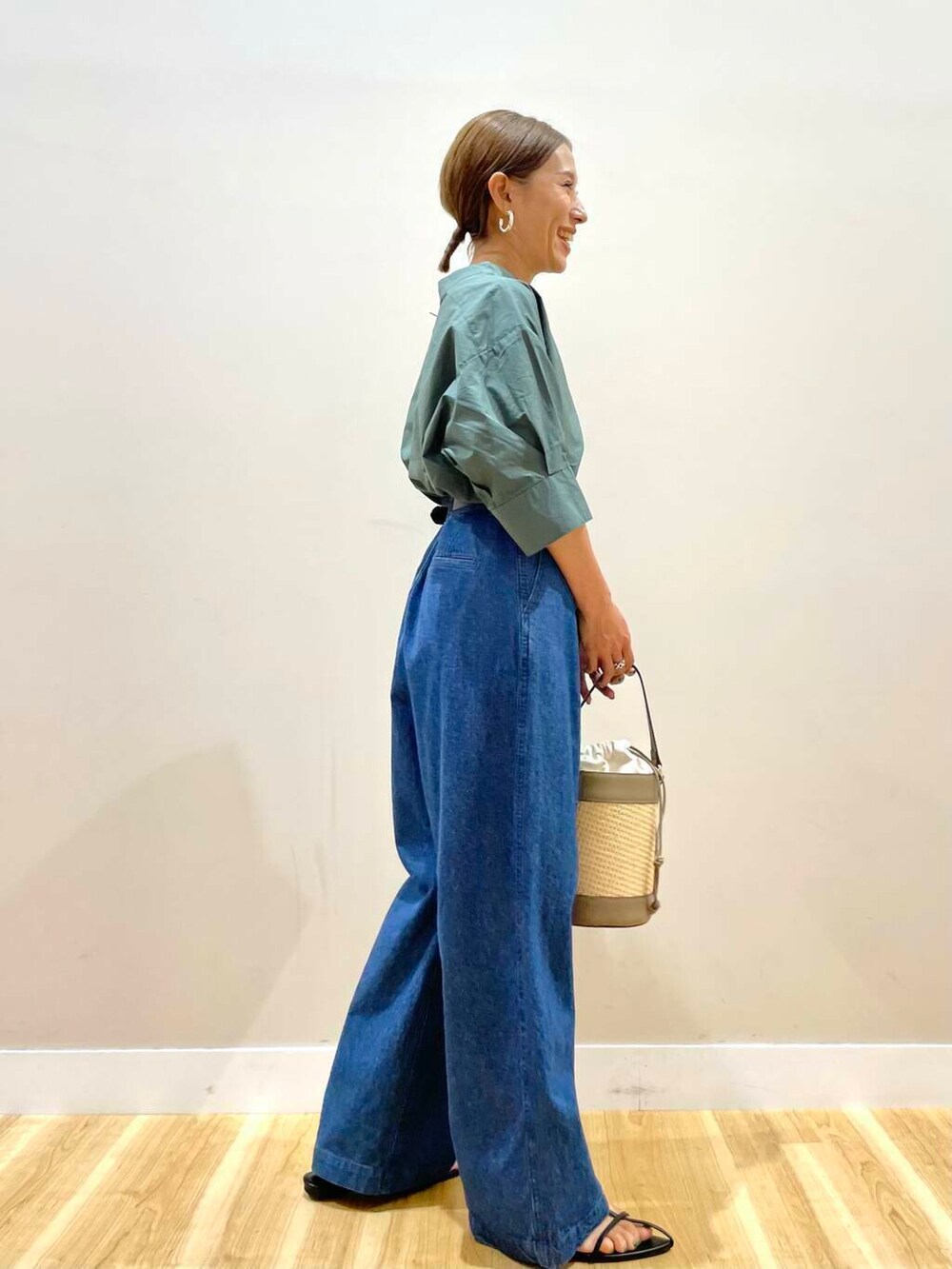 グリーン系のシャツ/ブラウス、ブルー系のデニムパンツ、ブラック系のベルトを着用したレディースの夏コーディネートの2枚目の写真