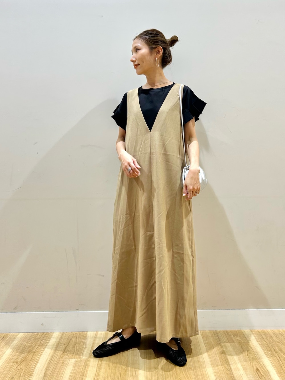 ブラック系のTシャツ/カットソー、ブラック系のその他シューズ、イエロー系のジャンパースカートを着用したレディースの春コーディネートの4枚目の写真