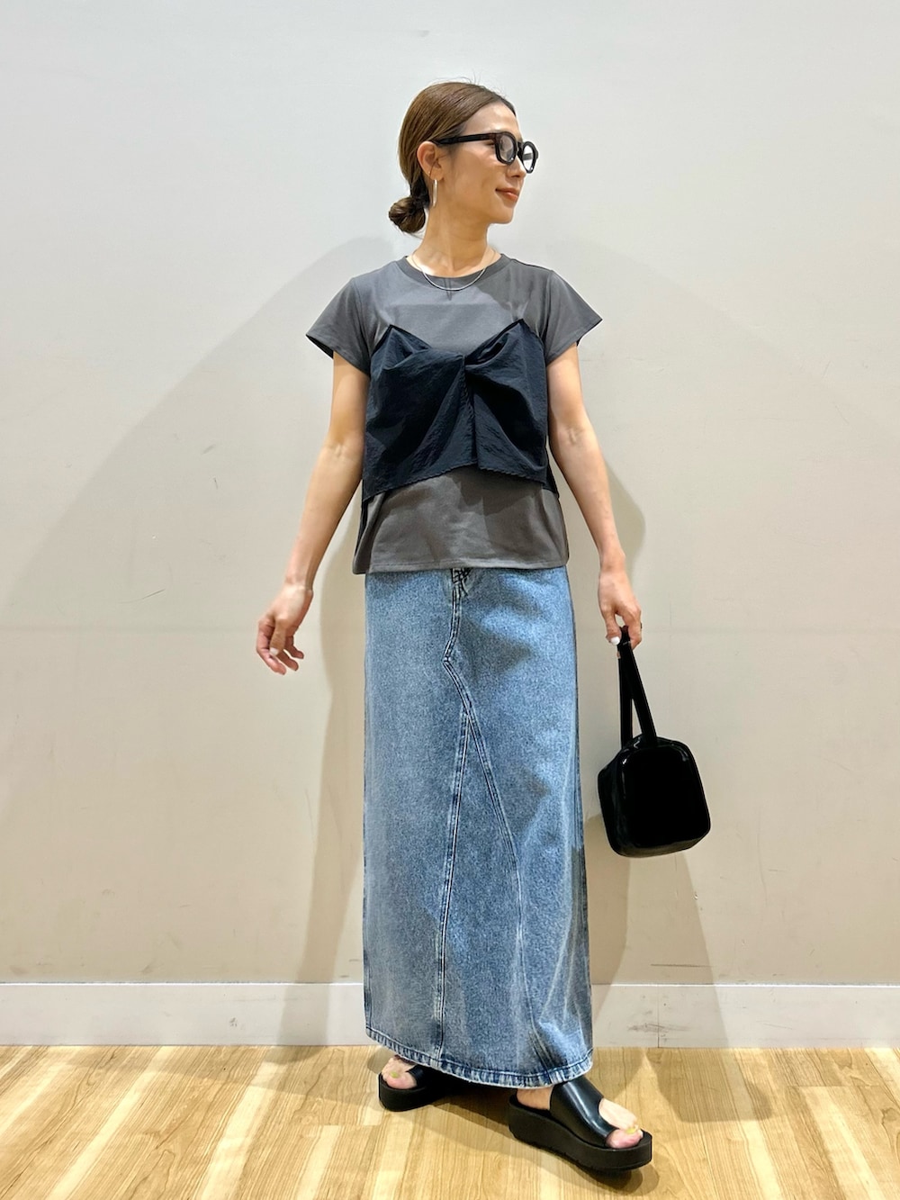 ブラック系のTシャツ/カットソー、ブルー系のスカート、ブラック系のトートバッグを着用したレディースの夏コーディネートの4枚目の写真