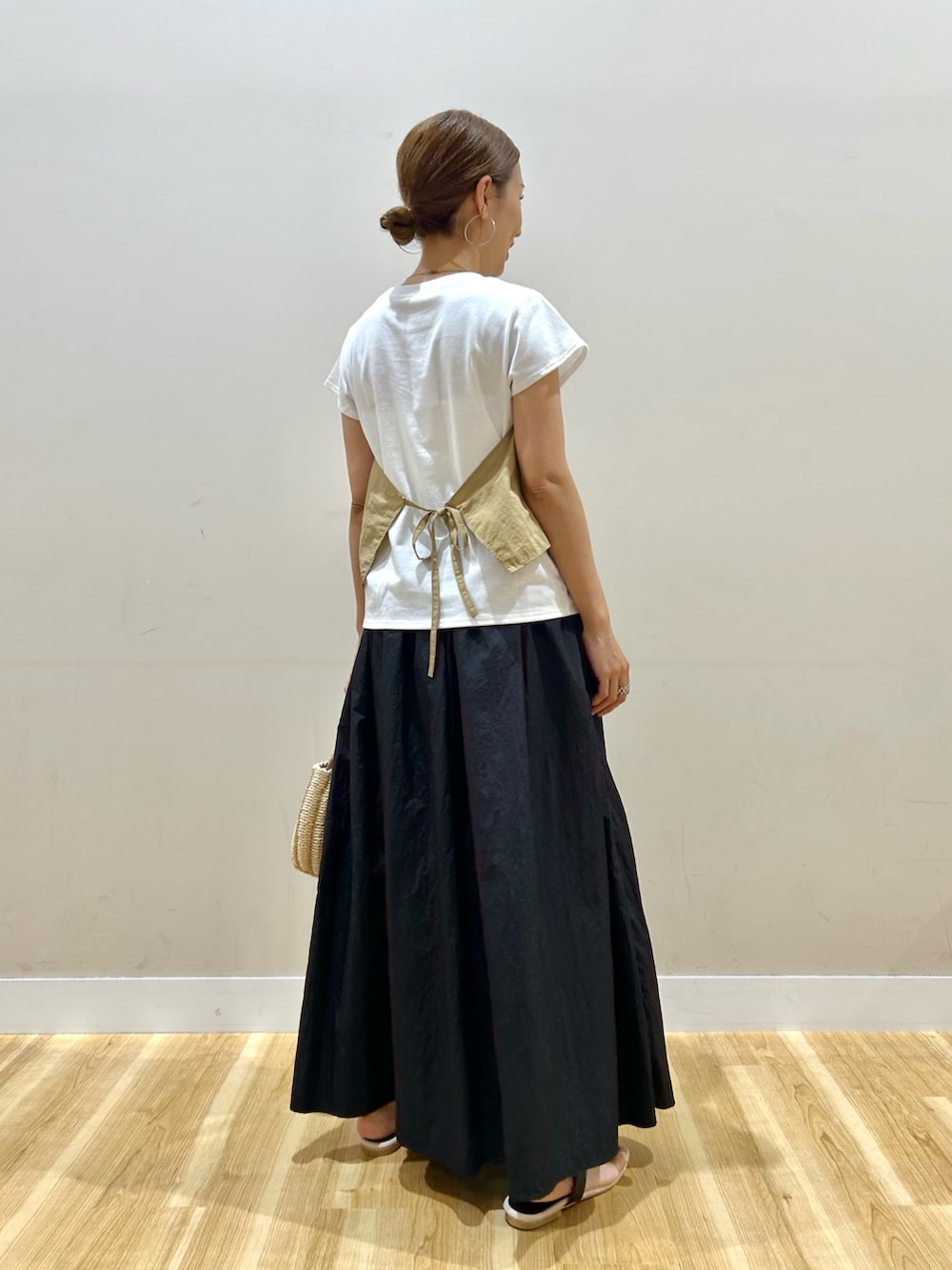 ベージュ系のTシャツ/カットソー、ブラック系のスカート、グレー系のハンドバッグを着用したレディースの夏コーディネートの4枚目の写真
