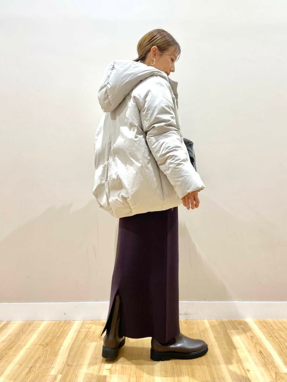 ブラウン系のブーツ、ホワイト系のダウンジャケット/コート、グレー系のニット/セーターを着用したレディースの冬コーディネートの4枚目の写真