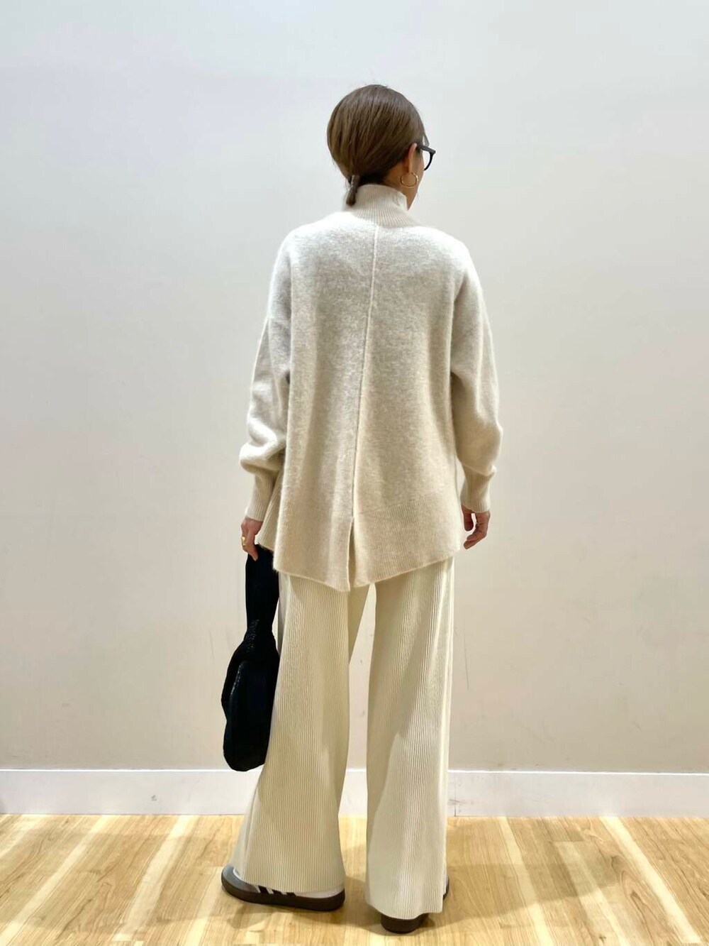 ホワイト系のその他パンツ、ブラック系のハンドバッグ、グリーン系のその他アウターを着用したレディースの冬コーディネートの7枚目の写真