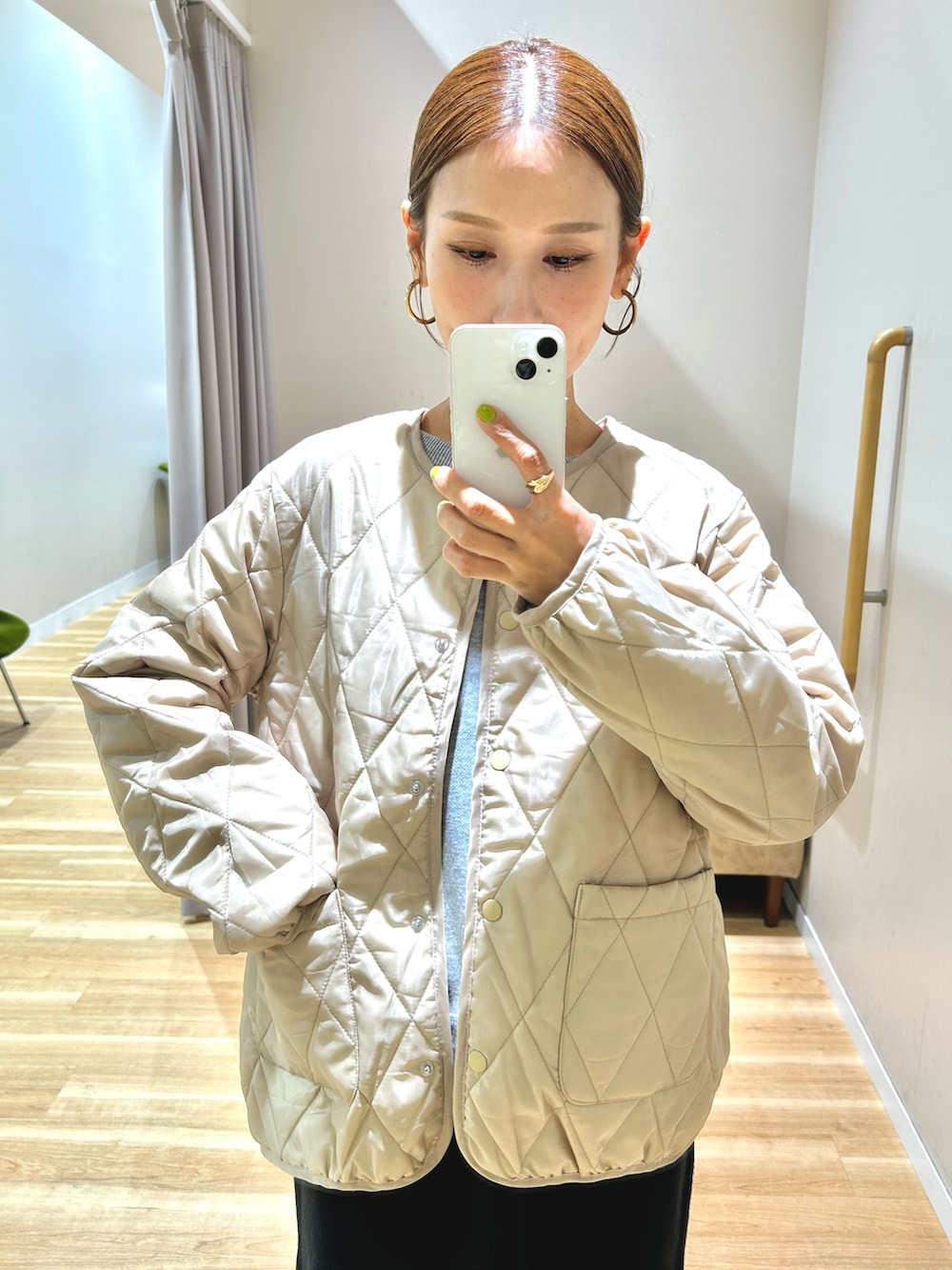 ベージュ系のダウンジャケット/コート、グレー系のニット/セーター、ブラック系のスカートを着用したレディースの秋コーディネートの8枚目の写真