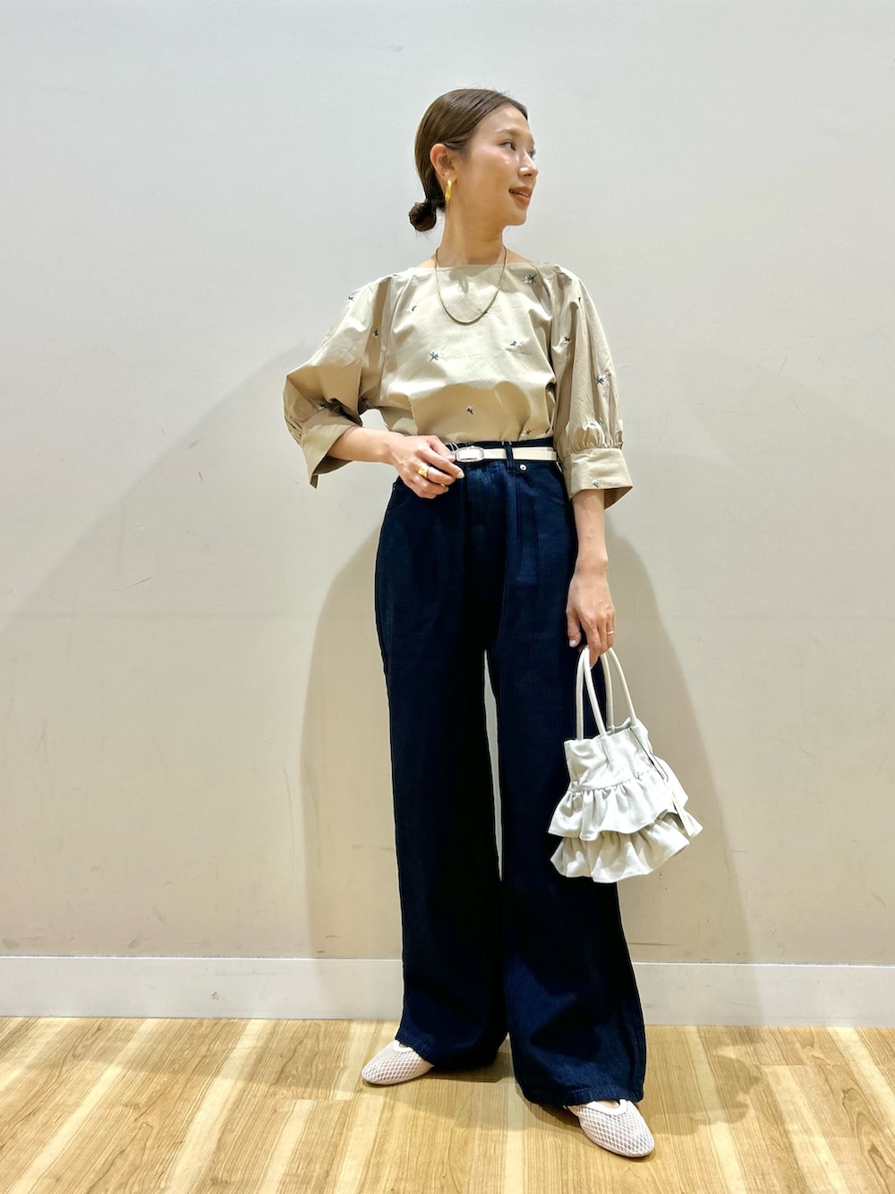 ベージュ系のシャツ/ブラウス、ブルー系のデニムパンツ、ホワイト系のハンドバッグを着用したレディースの春コーディネートの2枚目の写真