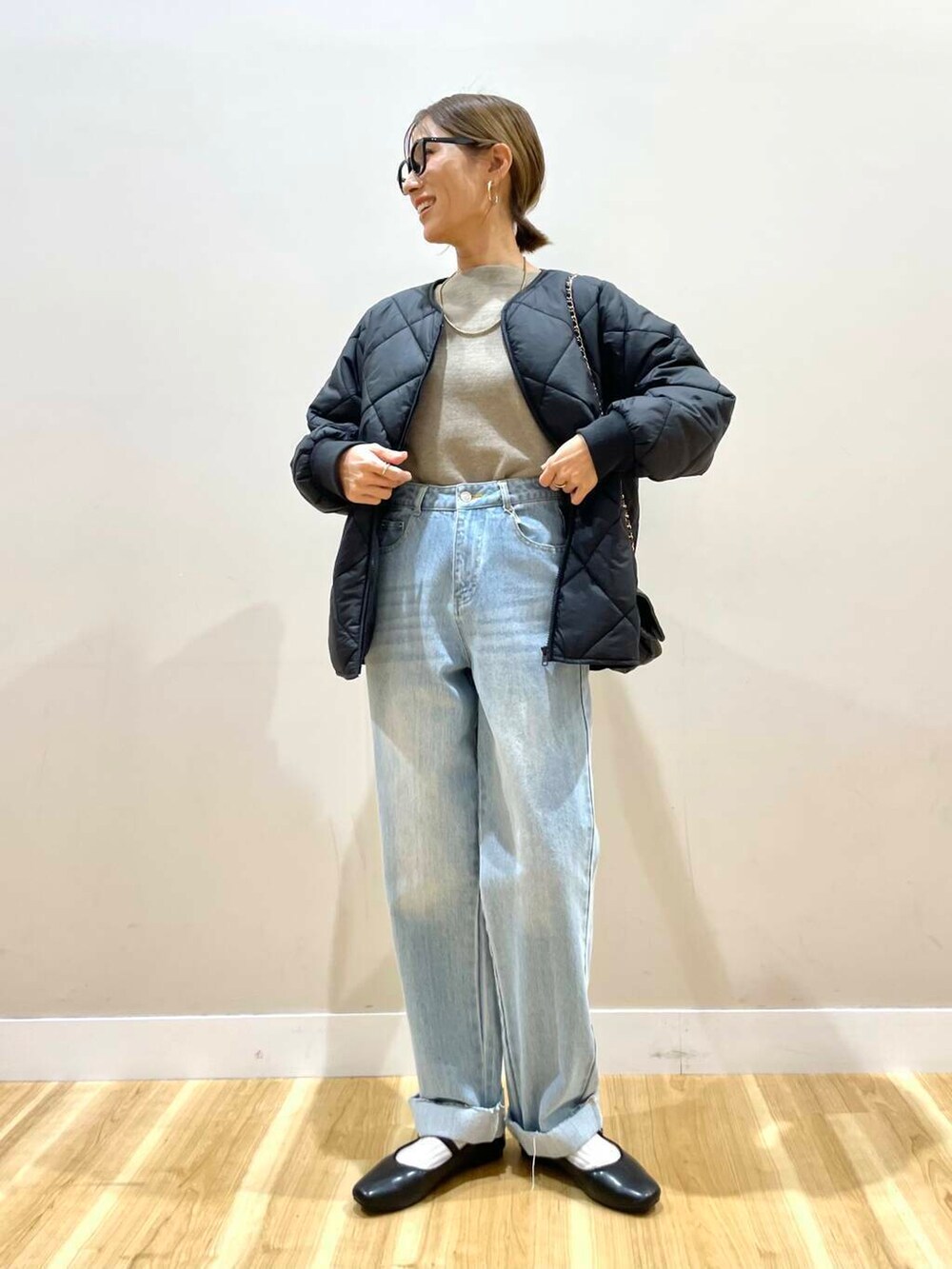 ブラック系のパンプス、ベージュ系のニット/セーター、ブルー系のデニムパンツを着用したレディースの冬コーディネートの5枚目の写真