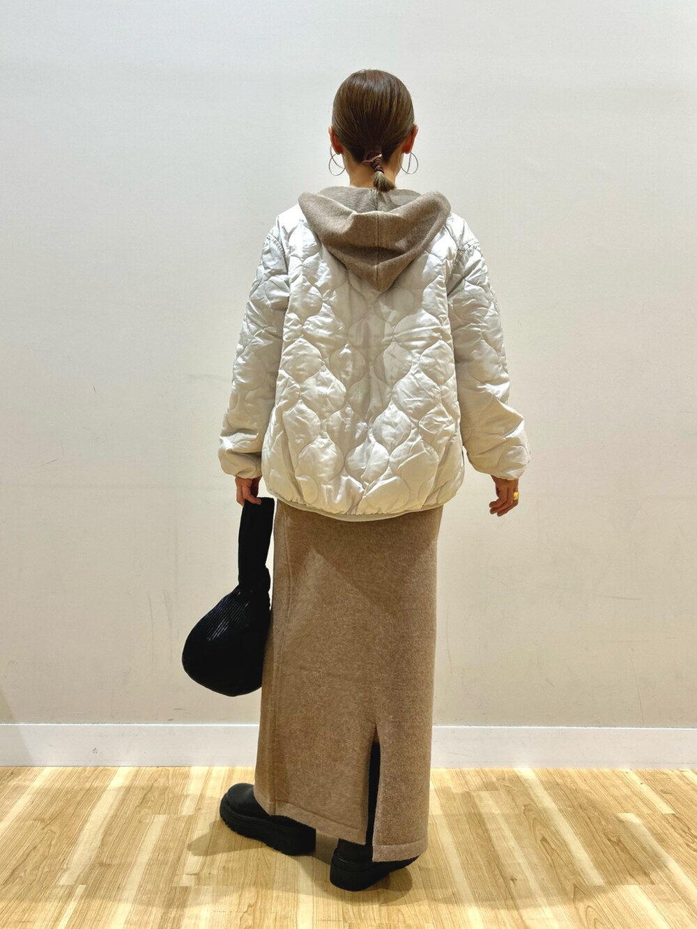 ベージュ系のニット/セーター、ホワイト系のTシャツ/カットソー、ホワイト系のダウンジャケット/コートを着用したレディースの秋コーディネートの3枚目の写真