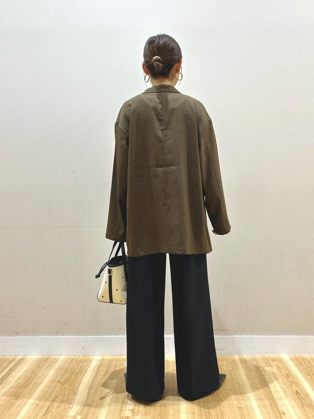 ブラウン系のその他アウター、ホワイト系のニット/セーター、ブラック系のその他パンツを着用したレディースの春コーディネートの3枚目の写真