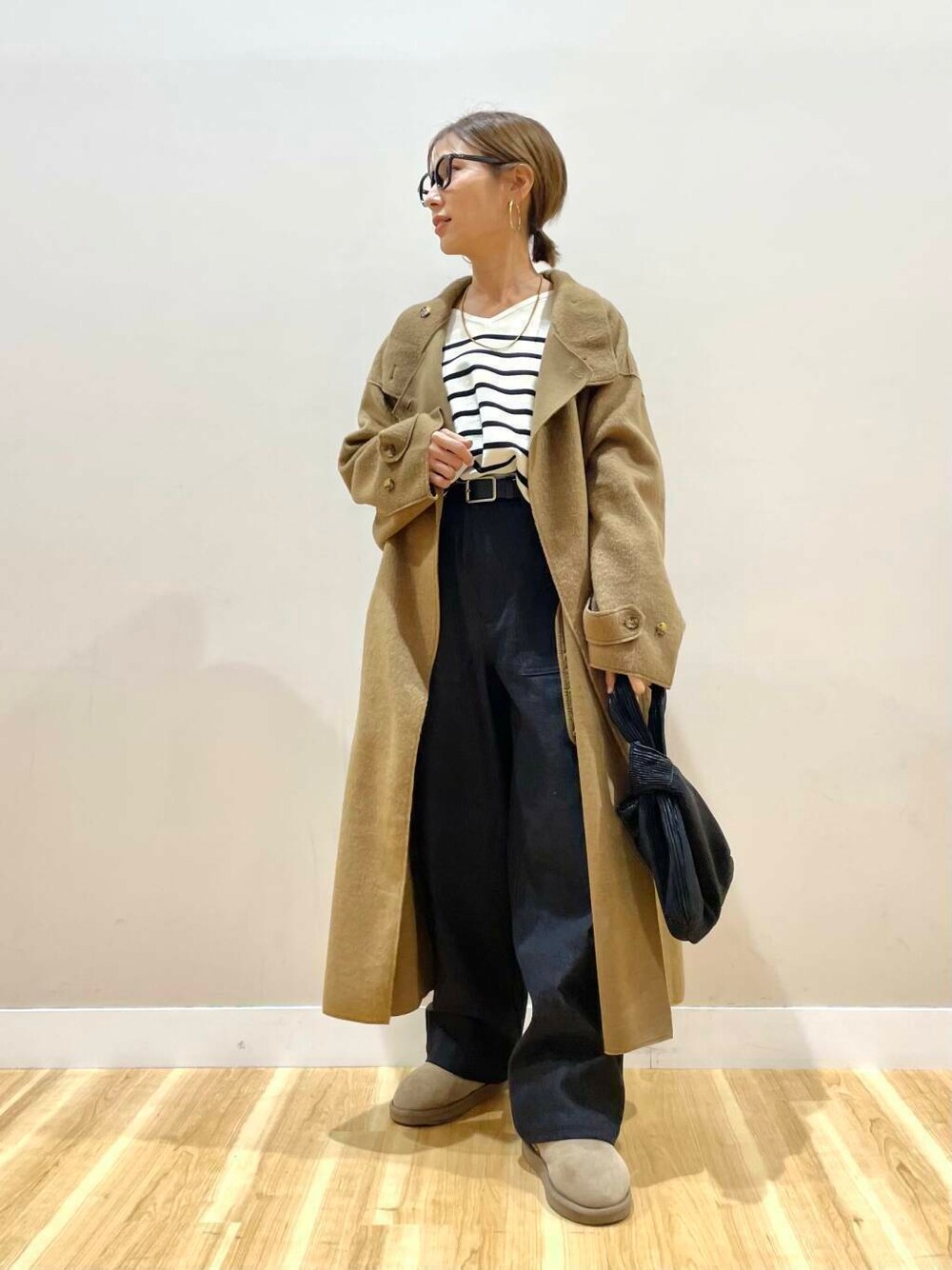 ブラック系のハンドバッグ、ブラック系のニット/セーター、ブラック系のデニムパンツを着用したレディースの秋コーディネートの2枚目の写真