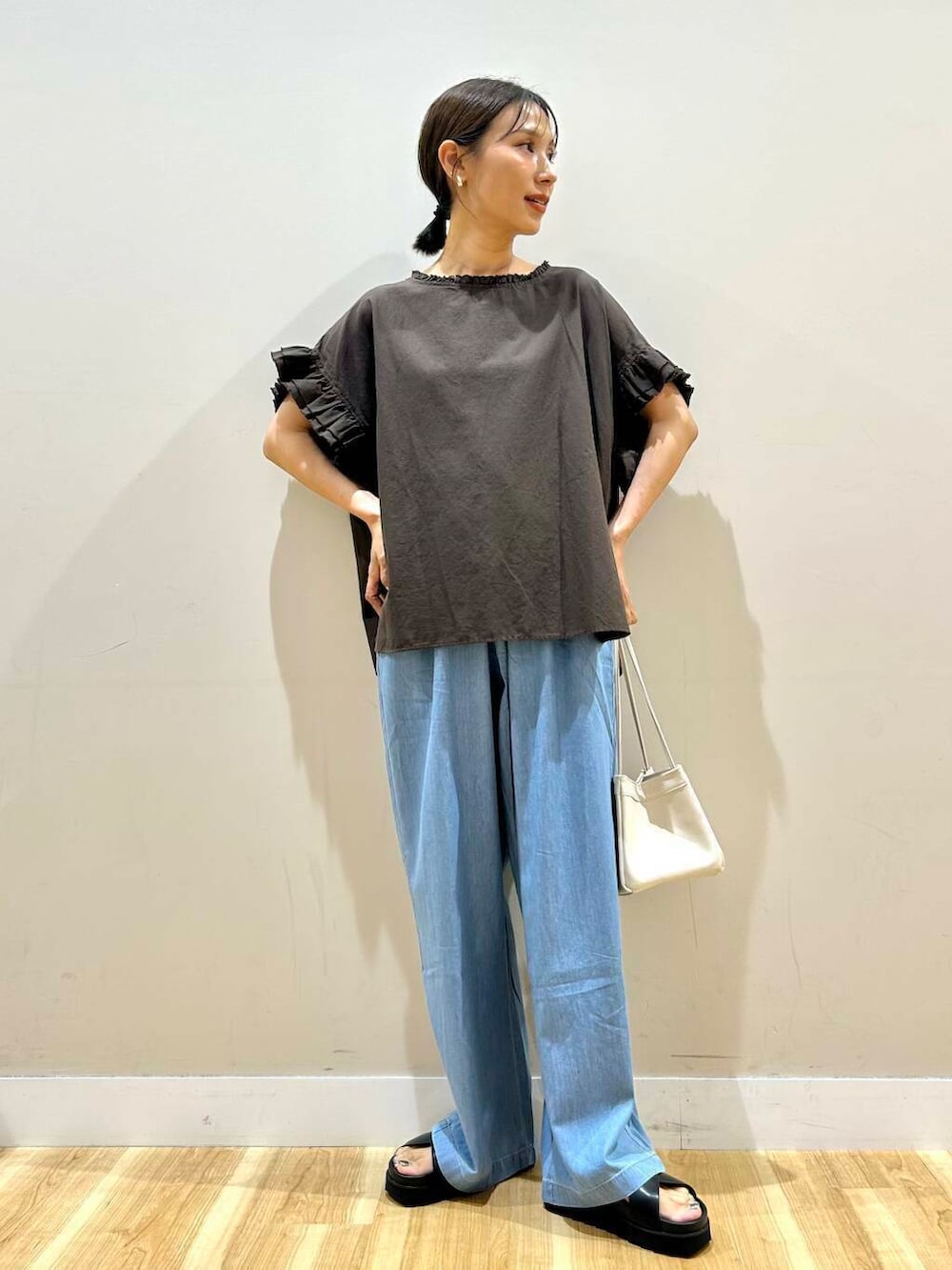 ホワイト系のハンドバッグ、ブラック系のサンダル、ブラウン系のシャツ/ブラウスを着用したレディースの夏コーディネートの4枚目の写真