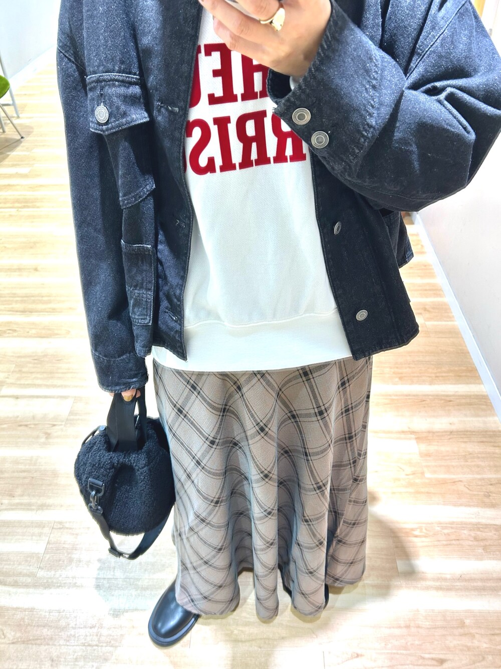 ブラック系のデニムジャケット、ホワイト系のスウェット、ブラウン系のスカートを着用したレディースの秋コーディネートの6枚目の写真