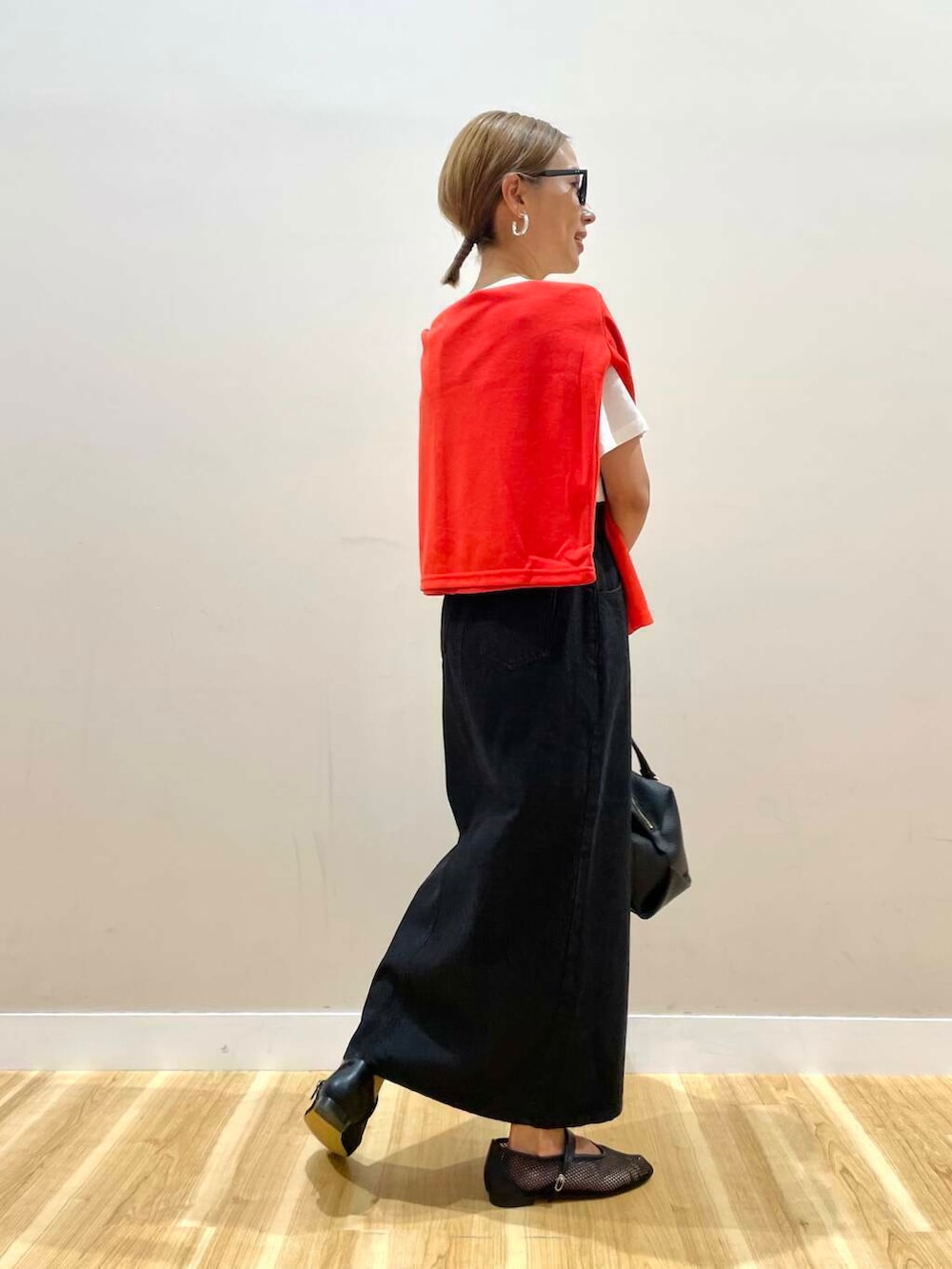 ブラック系のハンドバッグ、ブラック系のその他シューズ、ホワイト系のTシャツ/カットソーを着用したレディースの夏コーディネートの4枚目の写真