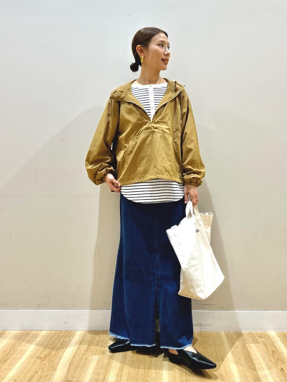 イエロー系のブルゾン、ホワイト系のTシャツ/カットソー、ブルー系のスカートを着用したレディースの春コーディネートの4枚目の写真