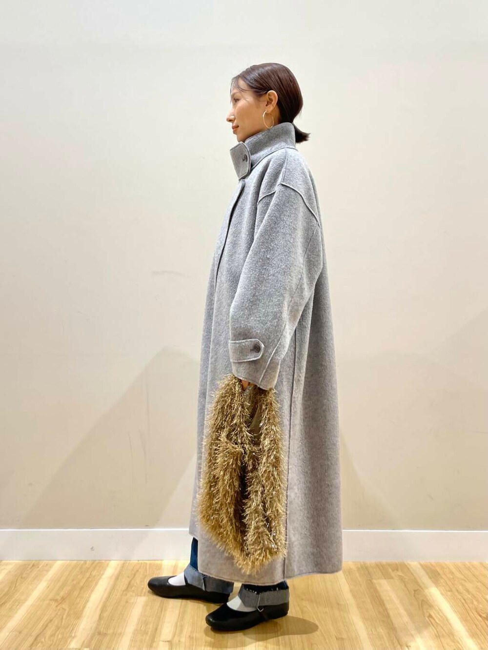 ブラック系のパンプス、ブルー系のデニムパンツ、グレー系のその他アウターを着用したレディースの冬コーディネートの4枚目の写真