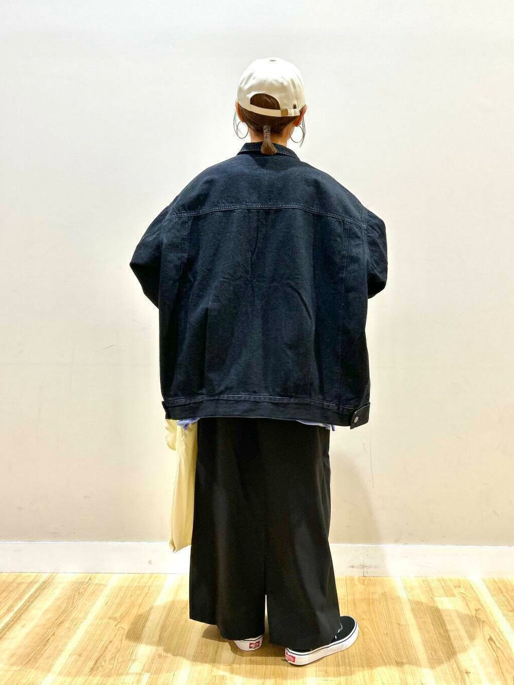 ブラック系のスニーカー、ホワイト系のトートバッグ、ブラック系のデニムジャケットを着用したレディースの春コーディネートの5枚目の写真