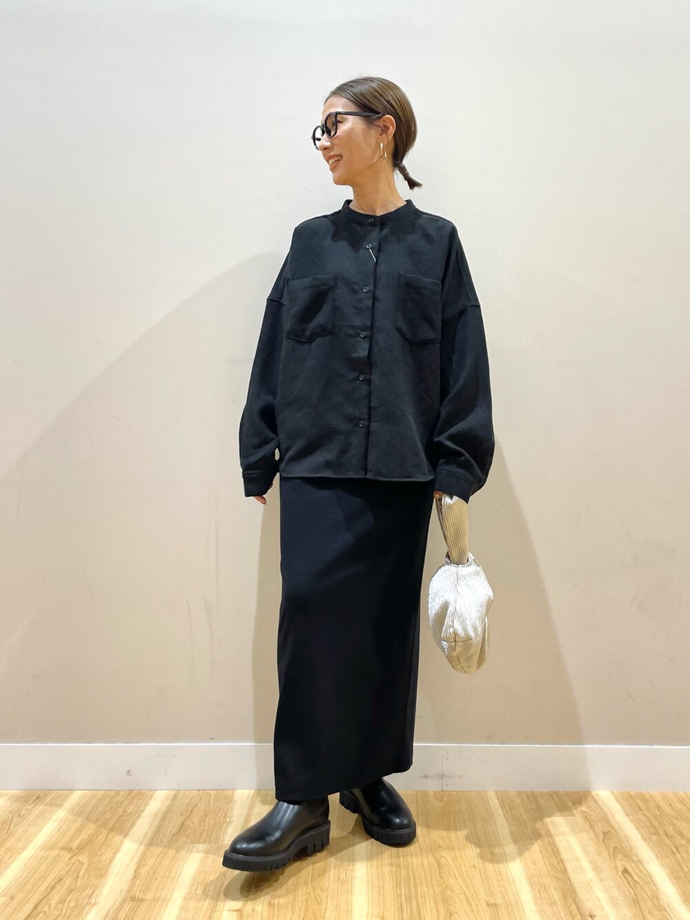 グレー系のベスト、ブラック系のTシャツ/カットソー、ブラック系のスカートを着用したレディースの秋コーディネートの8枚目の写真