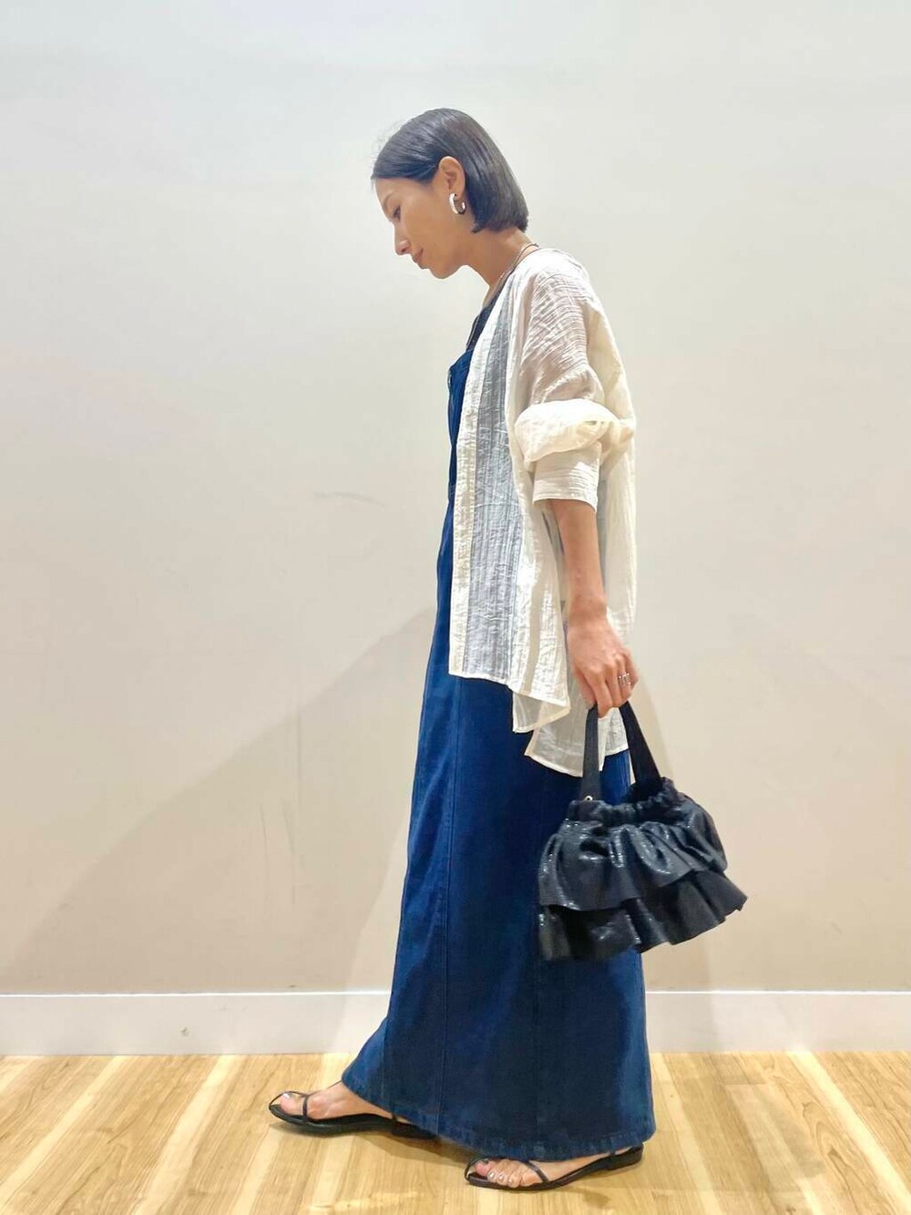 ブラック系のショルダーバッグ、ブルー系のワンピース、ホワイト系のシャツ/ブラウスを着用したレディースの秋コーディネートの2枚目の写真