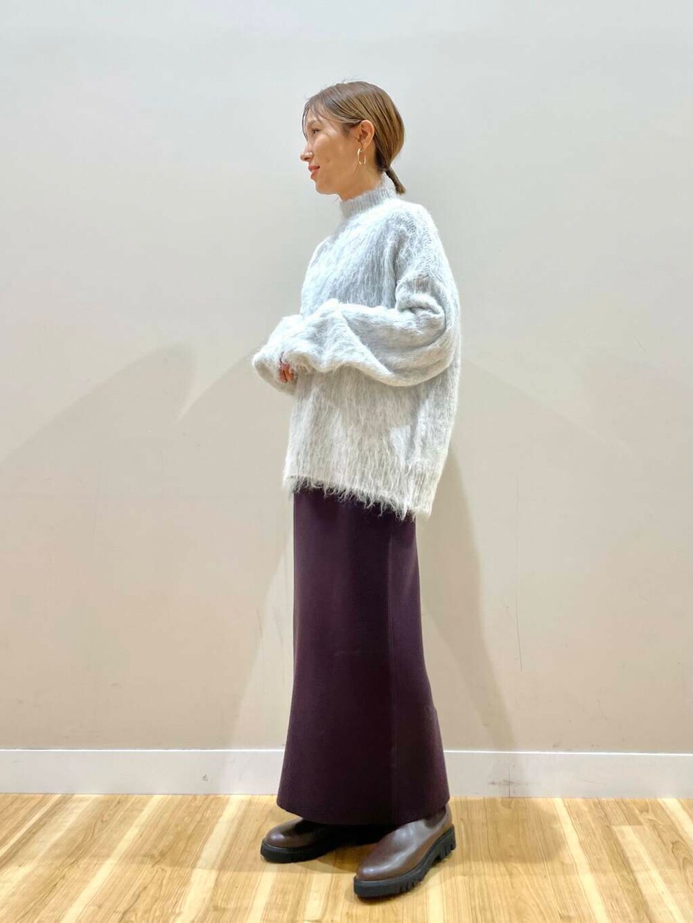 ブラウン系のブーツ、ホワイト系のダウンジャケット/コート、グレー系のニット/セーターを着用したレディースの冬コーディネートの7枚目の写真