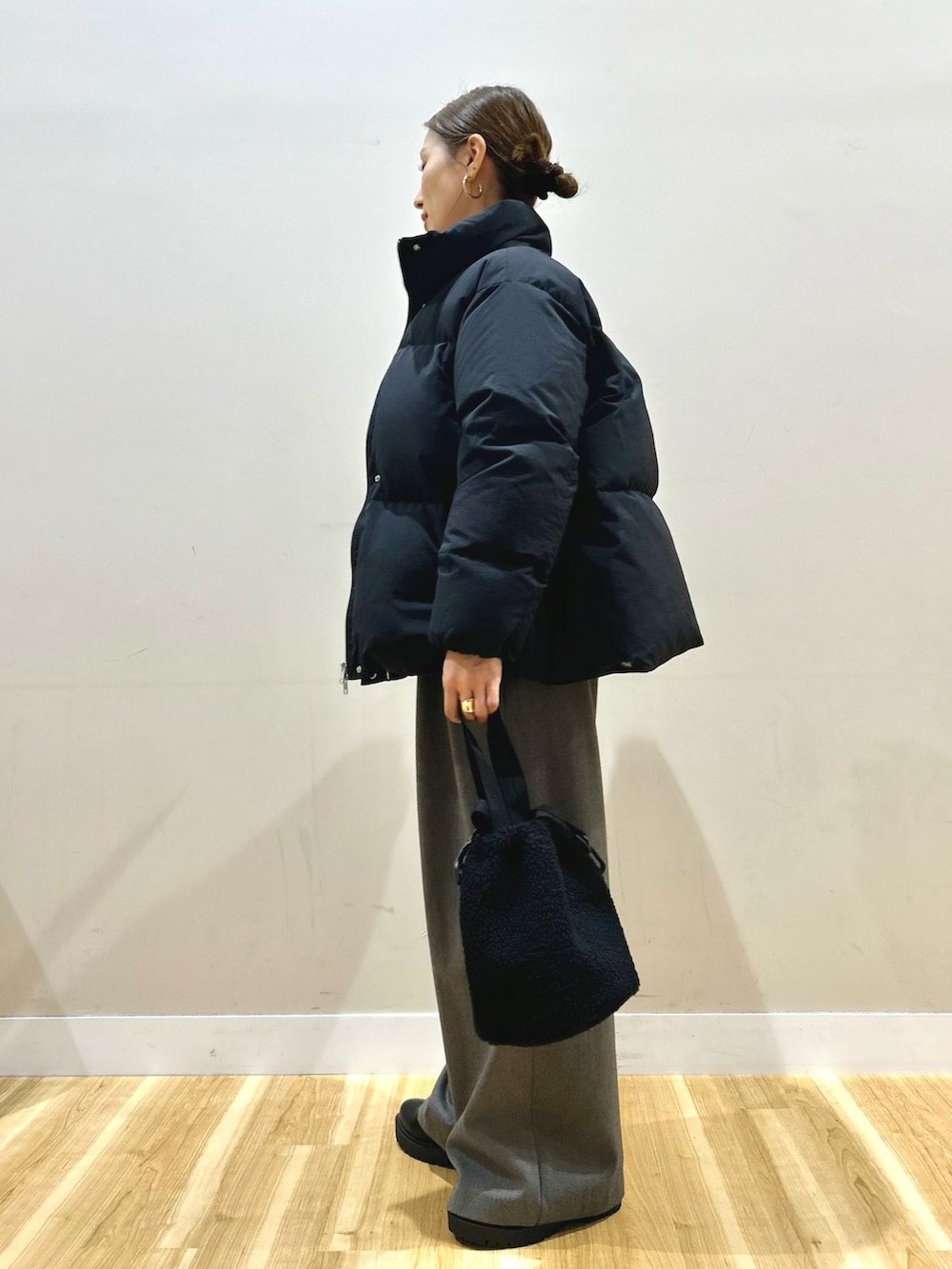 ブラック系のダウンジャケット/コート、ホワイト系のTシャツ/カットソー、ブラック系のブーツを着用したレディースの冬コーディネートの2枚目の写真