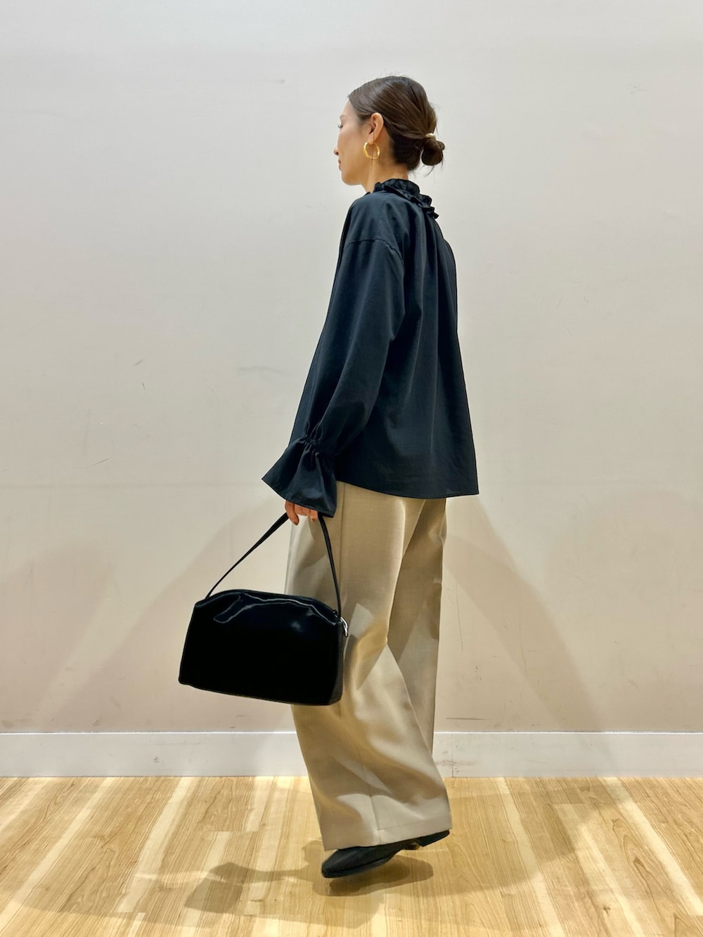 ブラック系のシャツ/ブラウス、ブラック系のトートバッグ、ベージュ系のその他パンツを着用したレディースの春コーディネートの4枚目の写真