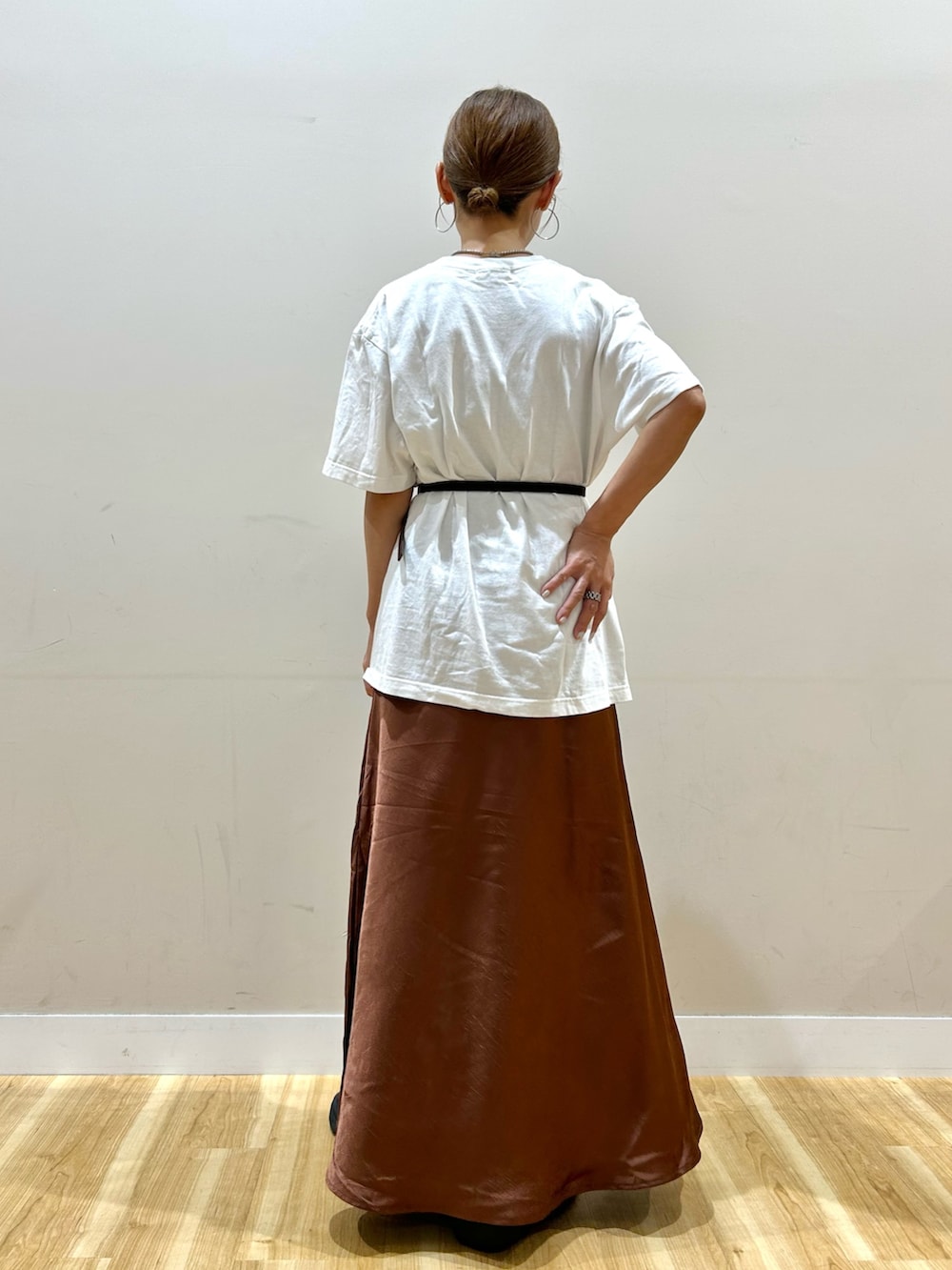 ホワイト系のTシャツ/カットソー、ブラウン系のスカート、ブラック系のブーツを着用したレディースの夏コーディネートの3枚目の写真