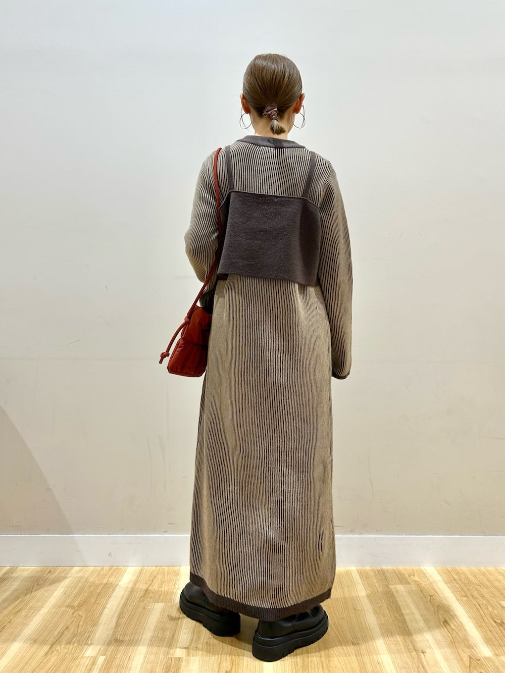 レッド系のショルダーバッグ、ベージュ系のワンピースを着用したレディースの冬コーディネートの3枚目の写真