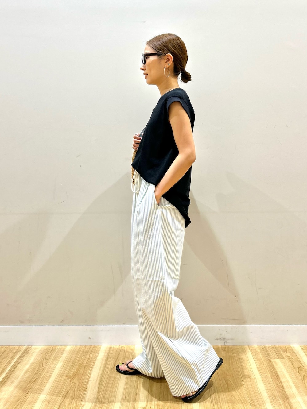 ブラック系のTシャツ/カットソー、ブルー系のその他パンツ、ブラック系のサンダルを着用したレディースの夏コーディネートの2枚目の写真