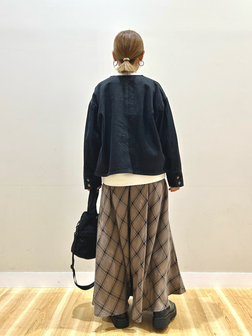 ブラック系のデニムジャケット、ホワイト系のスウェット、ブラウン系のスカートを着用したレディースの秋コーディネートの3枚目の写真