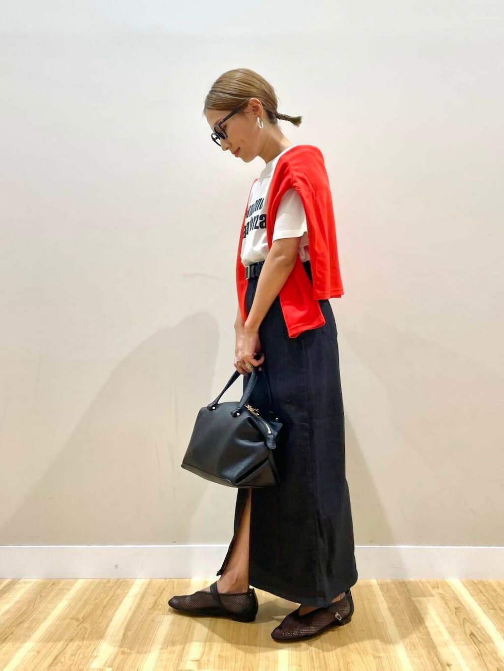 ブラック系のハンドバッグ、ブラック系のその他シューズ、ホワイト系のTシャツ/カットソーを着用したレディースの夏コーディネートの3枚目の写真