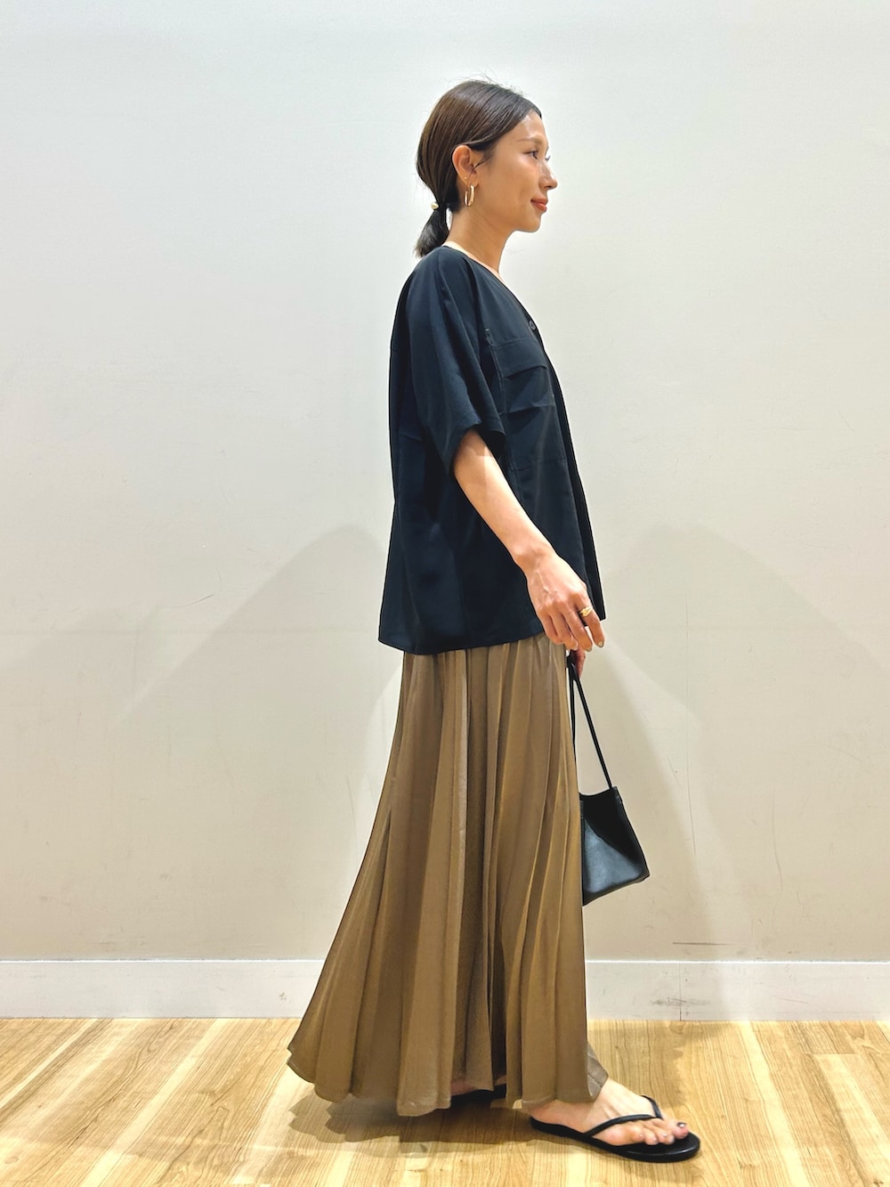 ブラック系のシャツ/ブラウス、ブラウン系のスカート、ブラック系のハンドバッグを着用したレディースの夏コーディネートの2枚目の写真