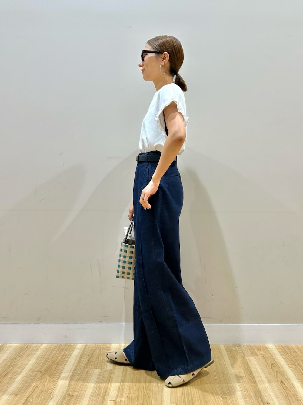 ホワイト系のTシャツ/カットソー、ブルー系のデニムパンツ、グリーン系のショルダーバッグを着用したレディースの夏コーディネートの4枚目の写真