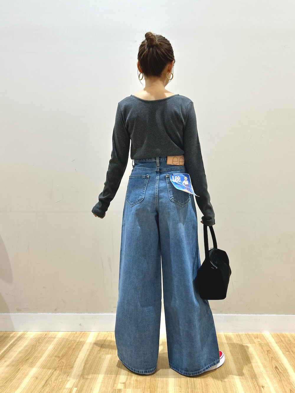 グレー系のステンカラーコート、グレー系のTシャツ/カットソー、ブルー系のデニムパンツを着用したレディースの春コーディネートの7枚目の写真