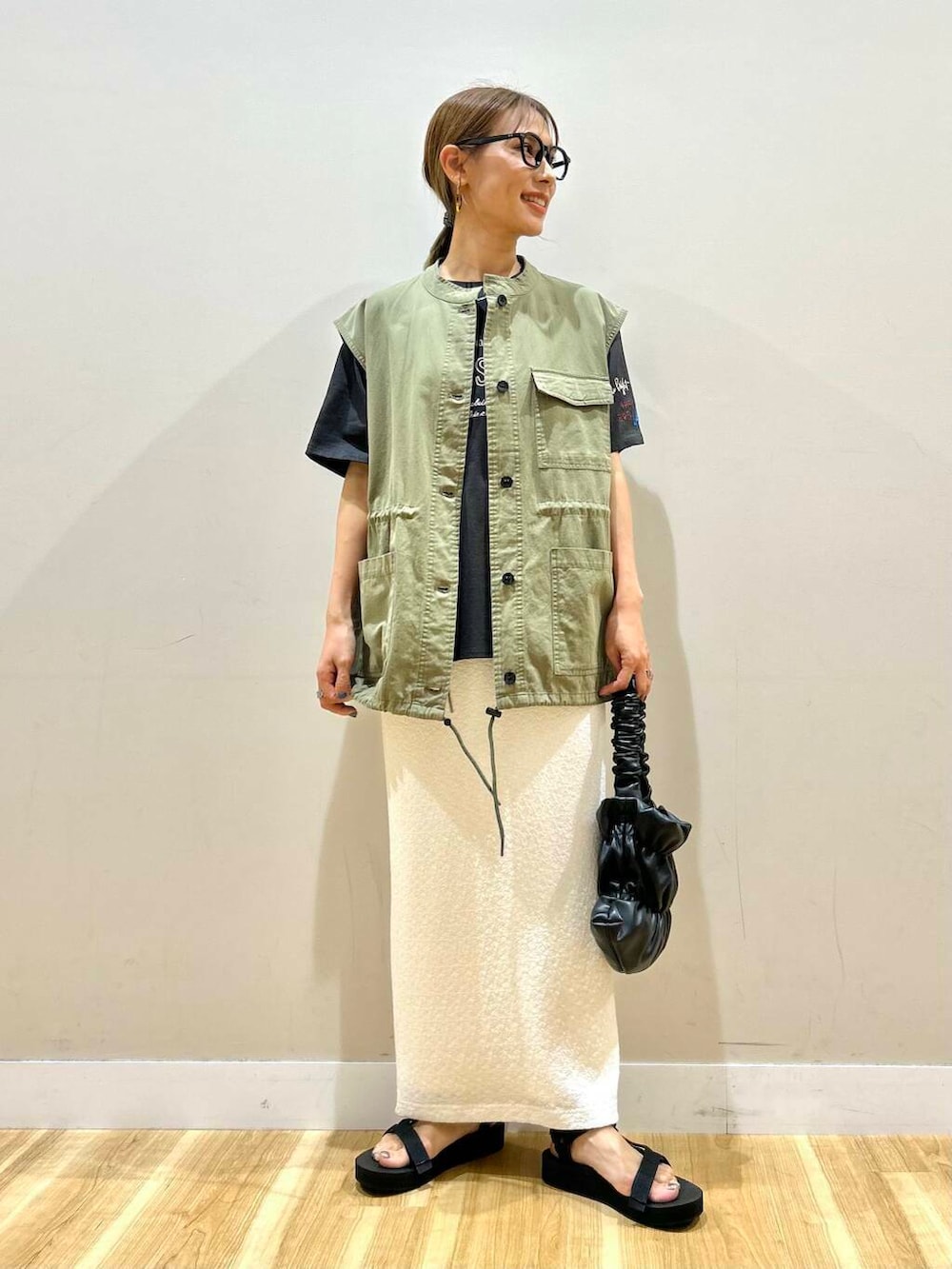 ブラック系のサンダル、ブラック系のハンドバッグ、グリーン系のその他アウターを着用したレディースの夏コーディネートの2枚目の写真