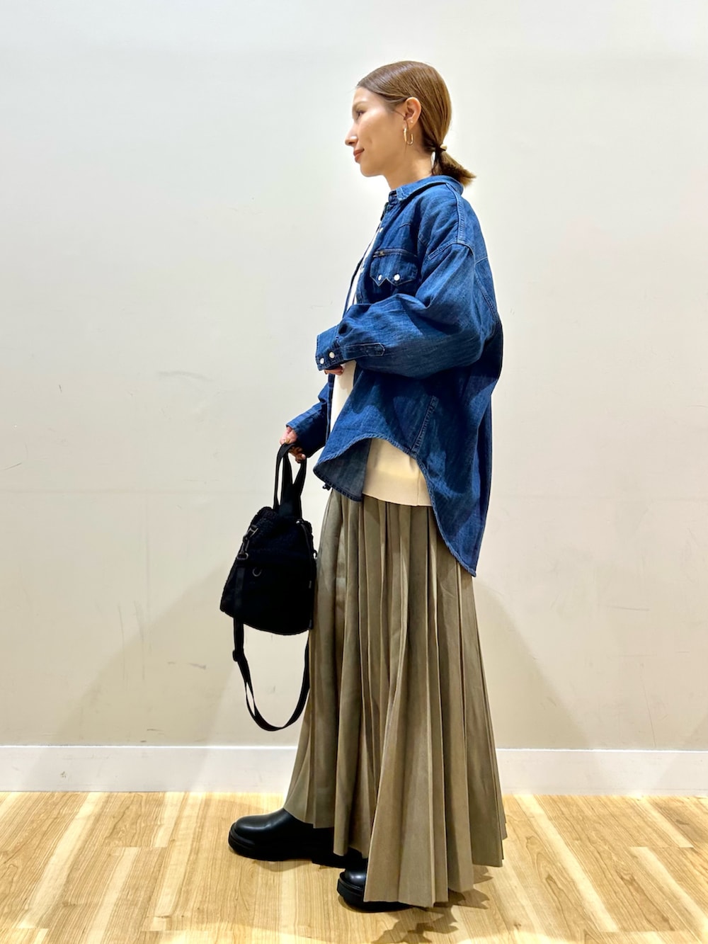 ブルー系のシャツ/ブラウス、ホワイト系のニット/セーター、グリーン系のスカートを着用したレディースの秋コーディネートの3枚目の写真