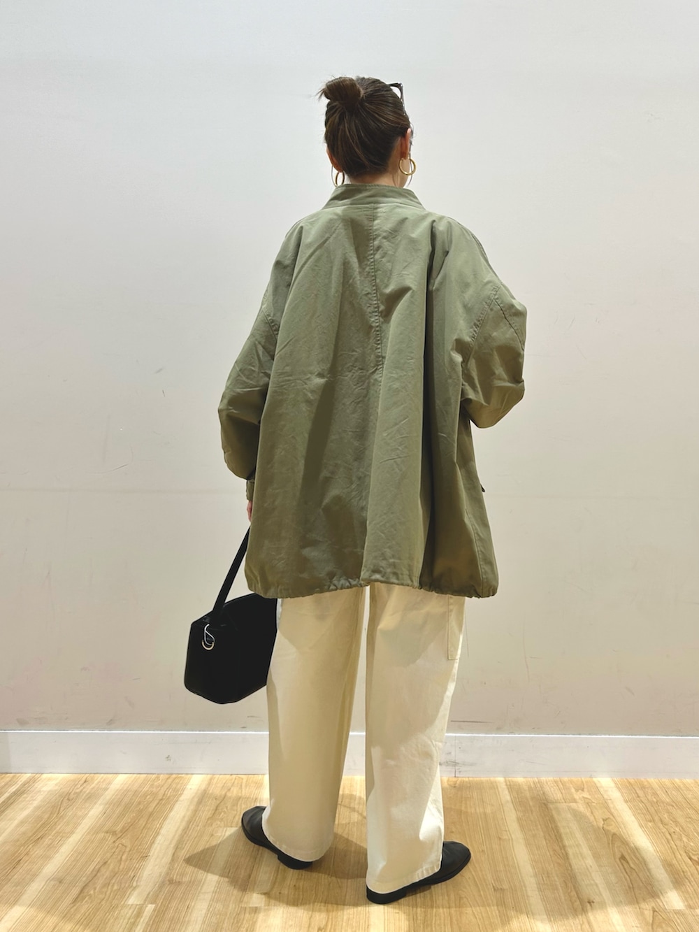 グリーン系のモッズコート、ブルー系のシャツ/ブラウス、ベージュ系のTシャツ/カットソーを着用したレディースの春コーディネートの4枚目の写真