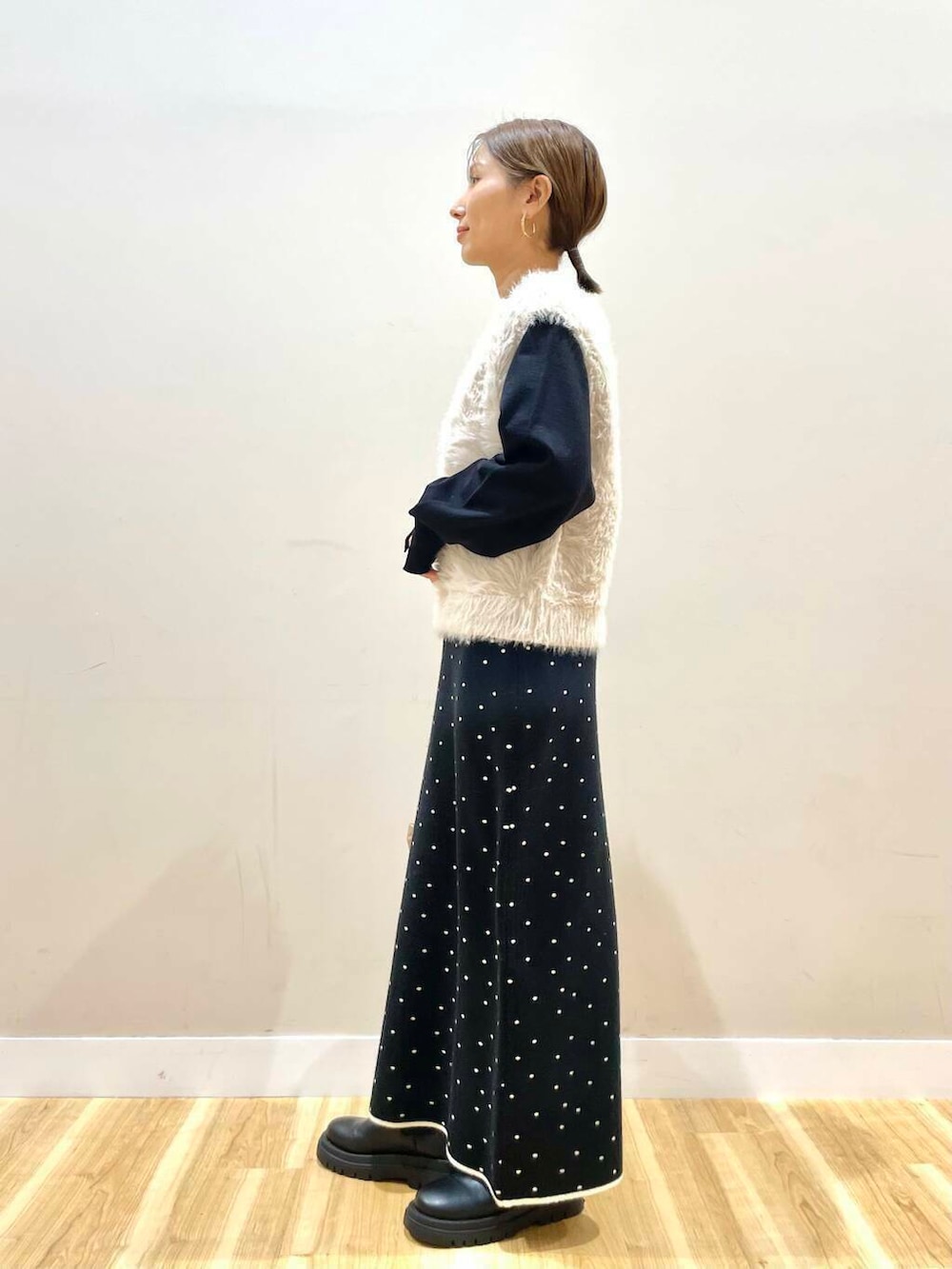 ブラウン系のショルダーバッグ、ブラック系のニット/セーター、ブラック系のスカートを着用したレディースの冬コーディネートの2枚目の写真