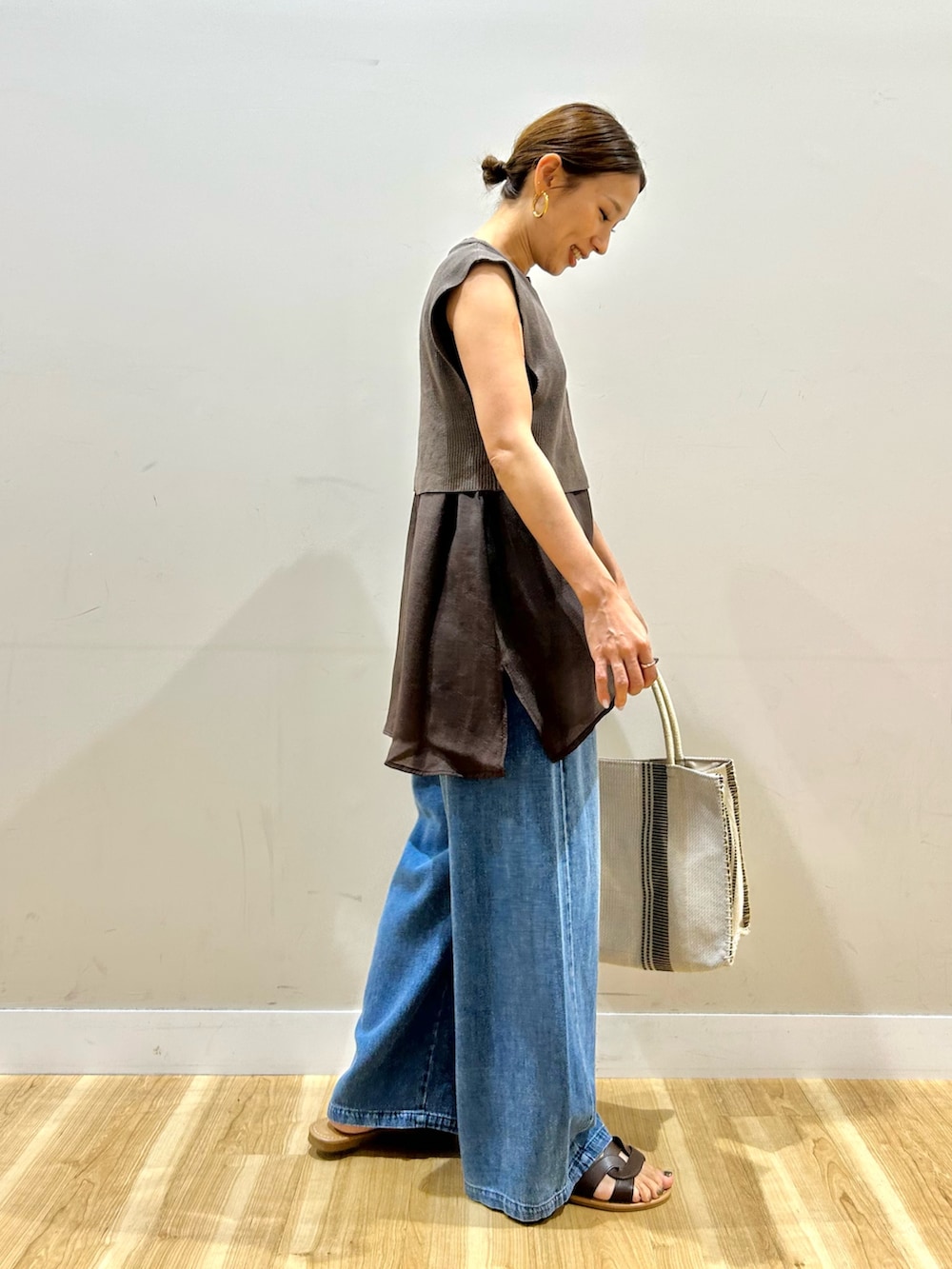 ブラウン系のシャツ/ブラウス、ブルー系のデニムパンツ、ホワイト系のトートバッグを着用したレディースの夏コーディネートの3枚目の写真