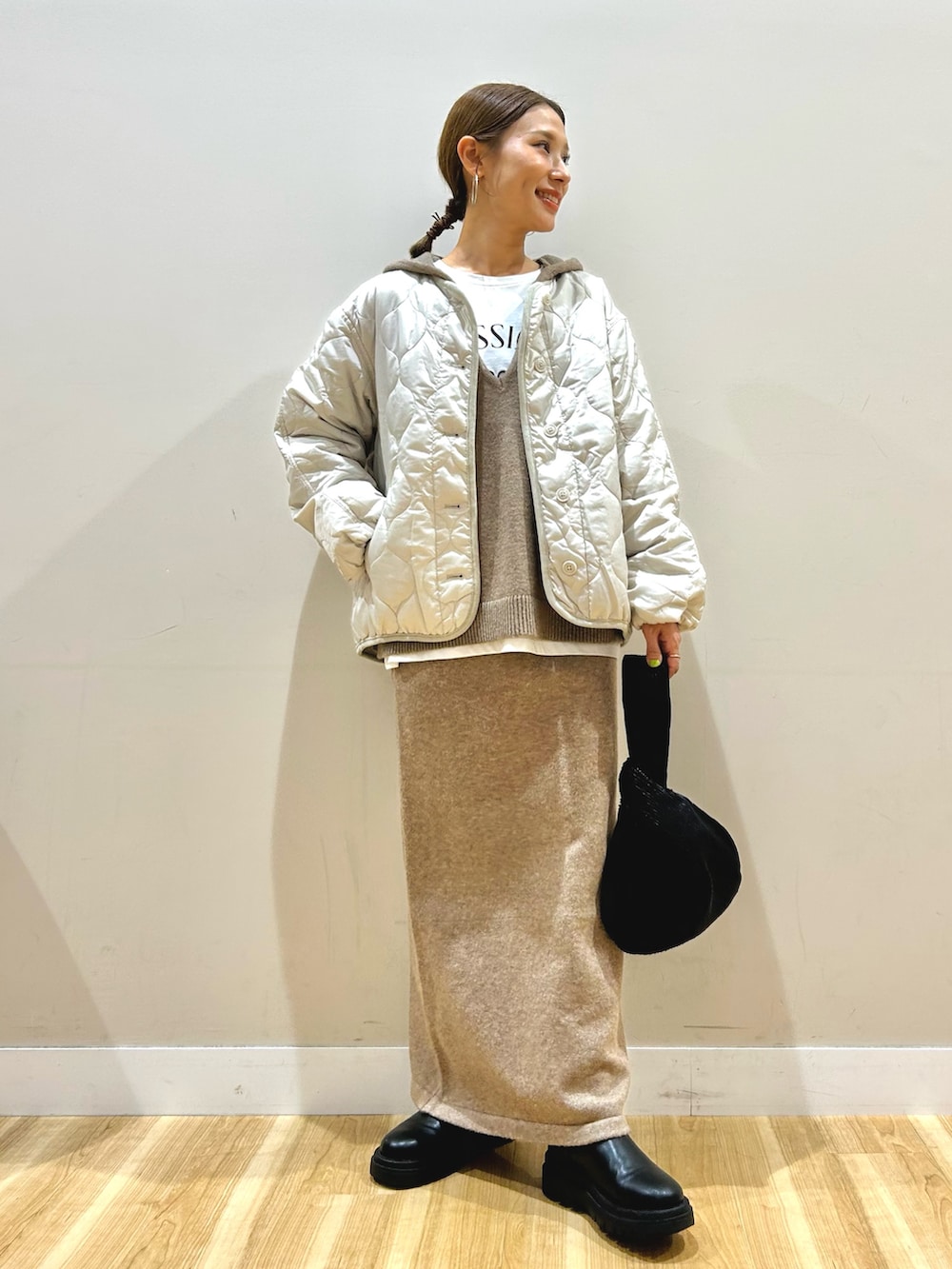 ベージュ系のニット/セーター、ホワイト系のTシャツ/カットソー、ホワイト系のダウンジャケット/コートを着用したレディースの秋コーディネートの9枚目の写真