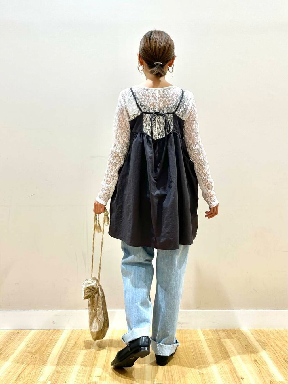 ブルー系のデニムパンツ、ベージュ系のショルダーバッグ、ブラック系のパンプスを着用したレディースの春コーディネートの3枚目の写真