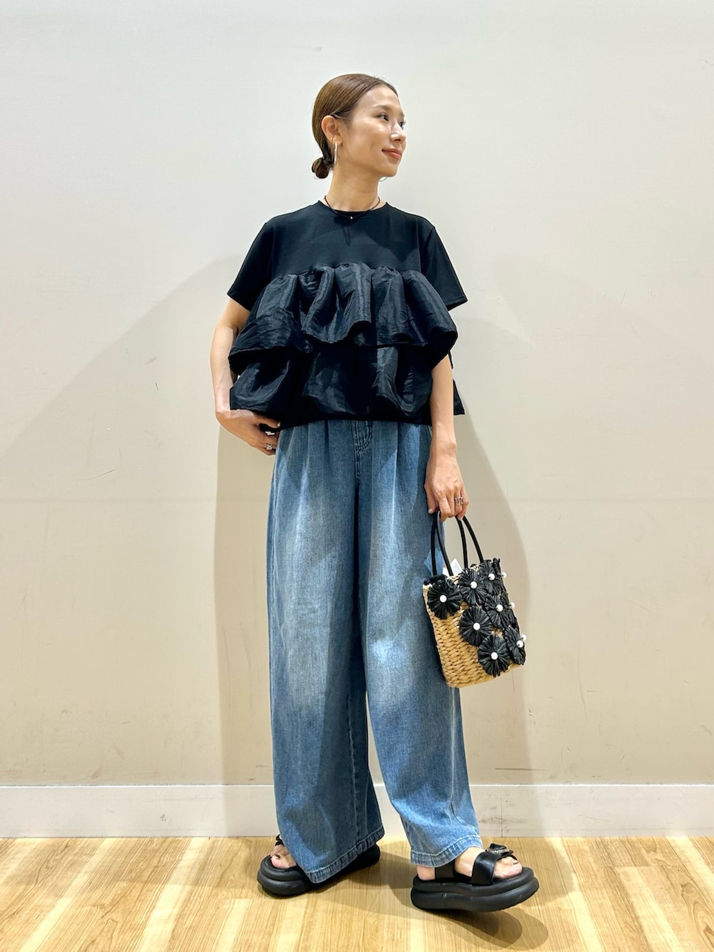 ブラック系のTシャツ/カットソー、ブルー系のデニムパンツ、ブラック系のかごバッグを着用したレディースの夏コーディネートの4枚目の写真