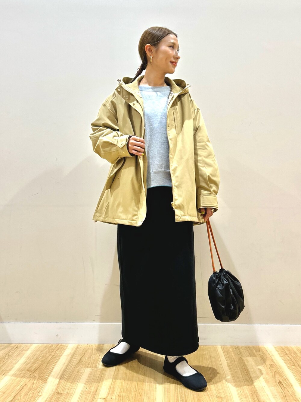 ベージュ系のダウンジャケット/コート、グレー系のニット/セーター、ブラック系のスカートを着用したレディースの秋コーディネートの10枚目の写真