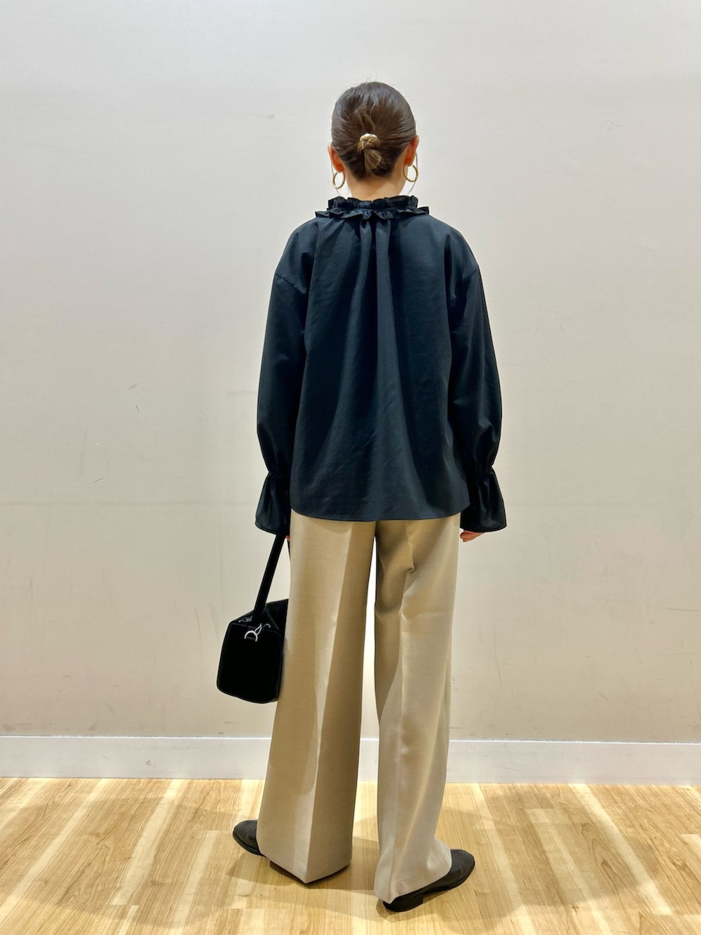 ブラック系のシャツ/ブラウス、ブラック系のトートバッグ、ベージュ系のその他パンツを着用したレディースの春コーディネートの3枚目の写真